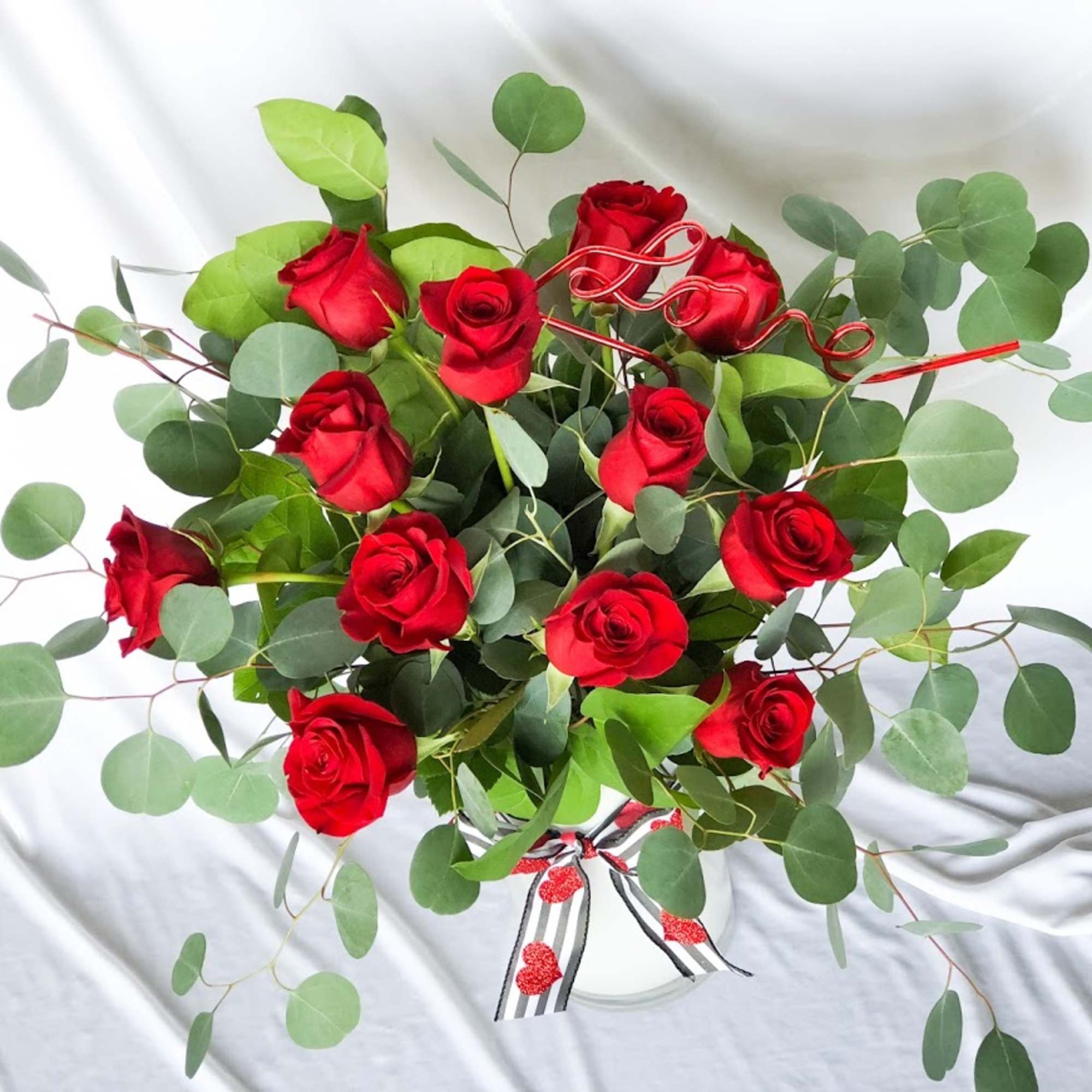 One dozen long stem red roses styled in a tall vase. This, photo 2 of 3