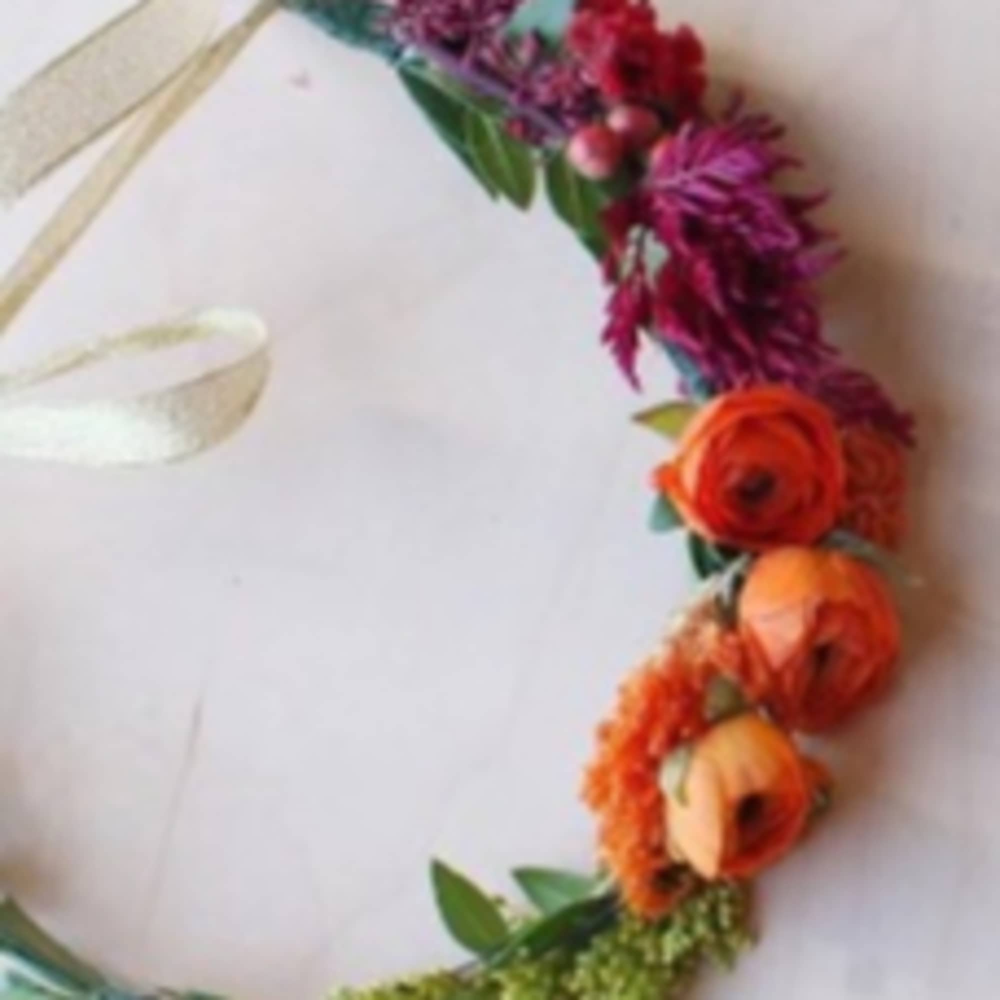 Colorful floral crown with orange and purple blooms on a ribbon