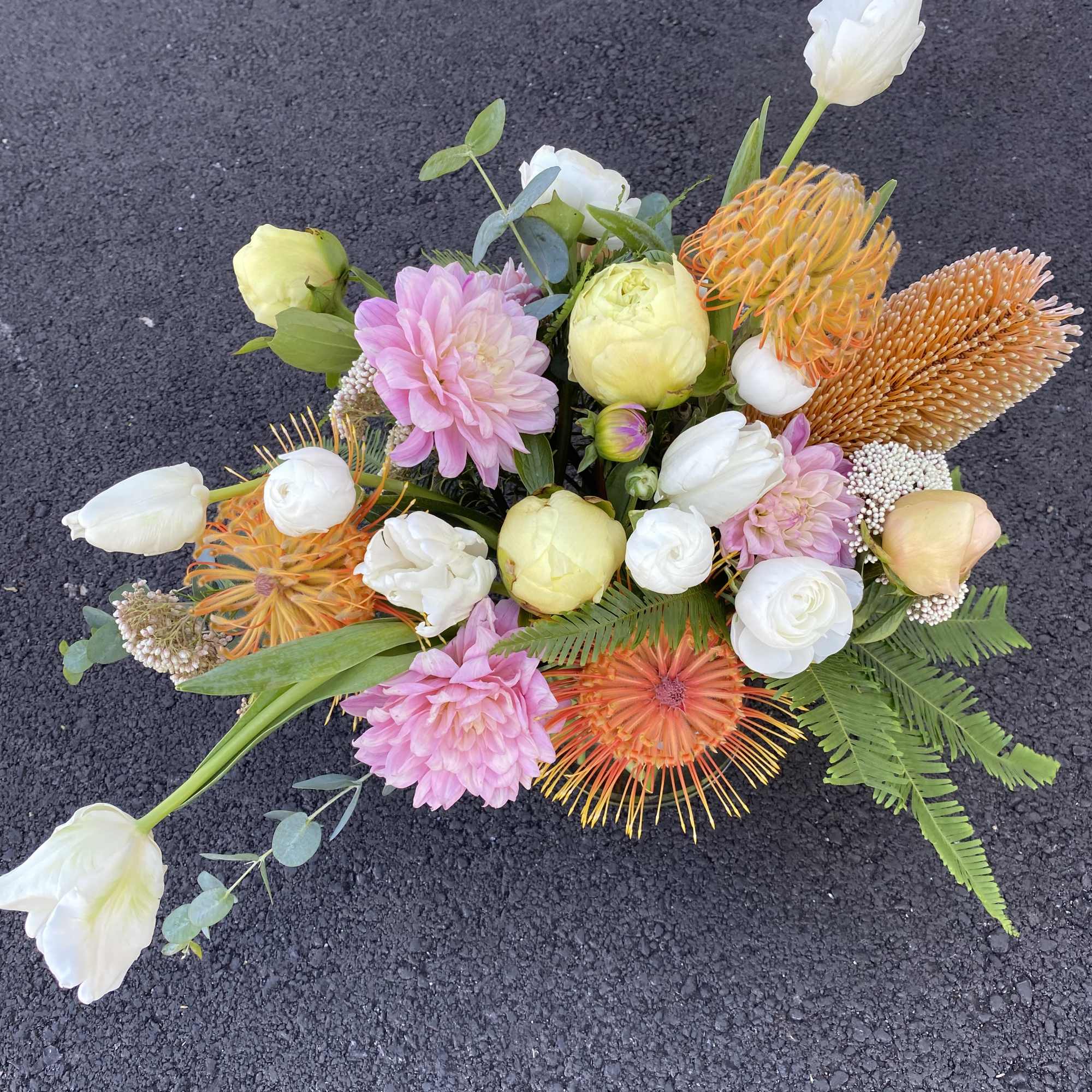 Mixed bouquet with pink, white, and orange flowers on a dark surface