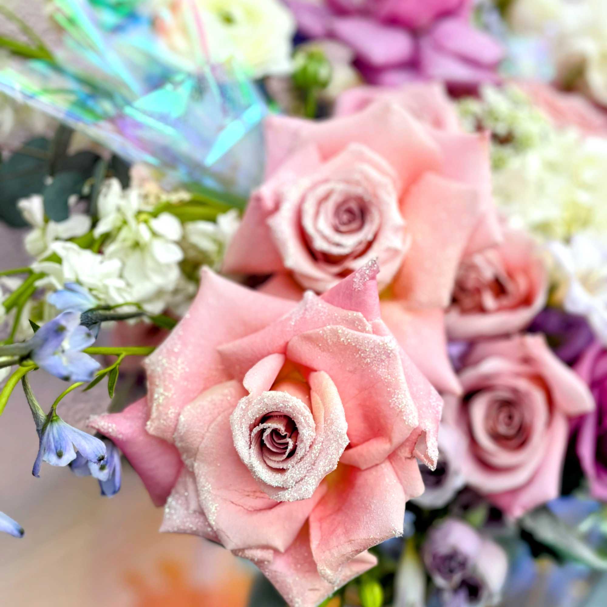 Pink roses with blue flowers and iridescent wrapping