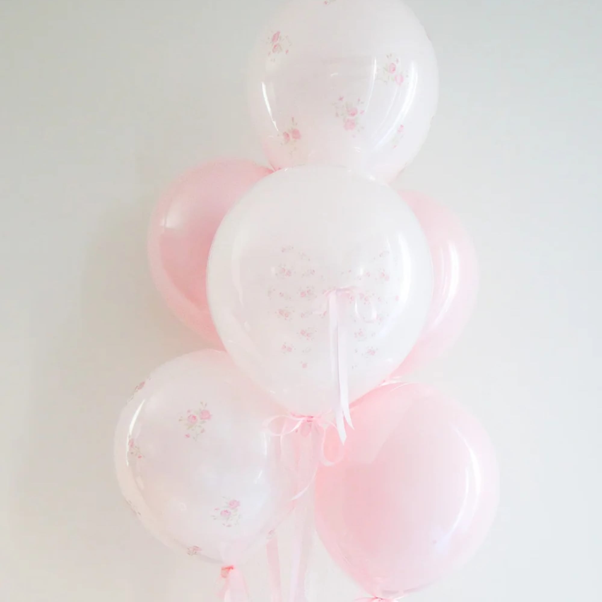 Cluster of pale pink and white balloons with small floral prints
