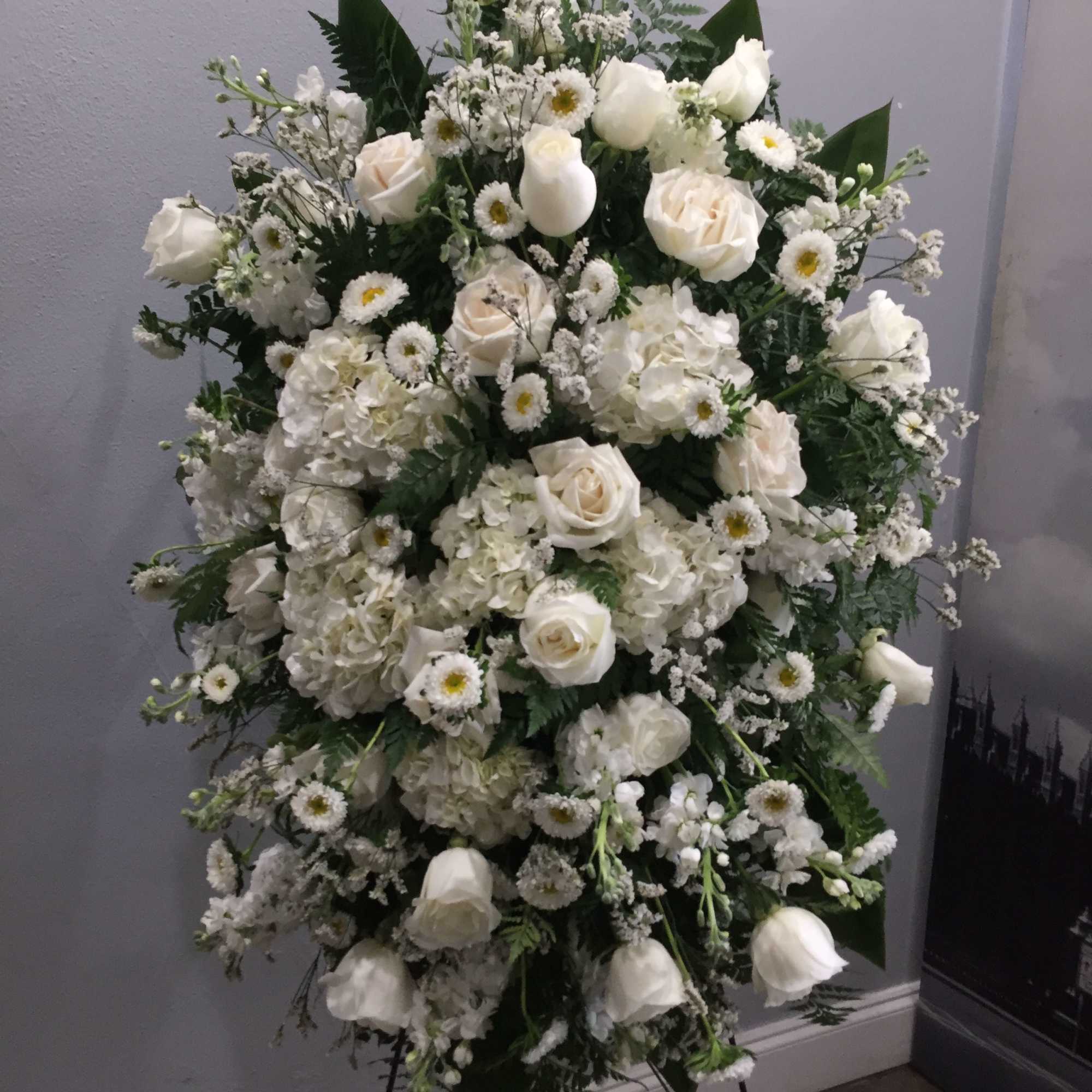Large white floral standing spray with roses, hydrangeas, and daisies