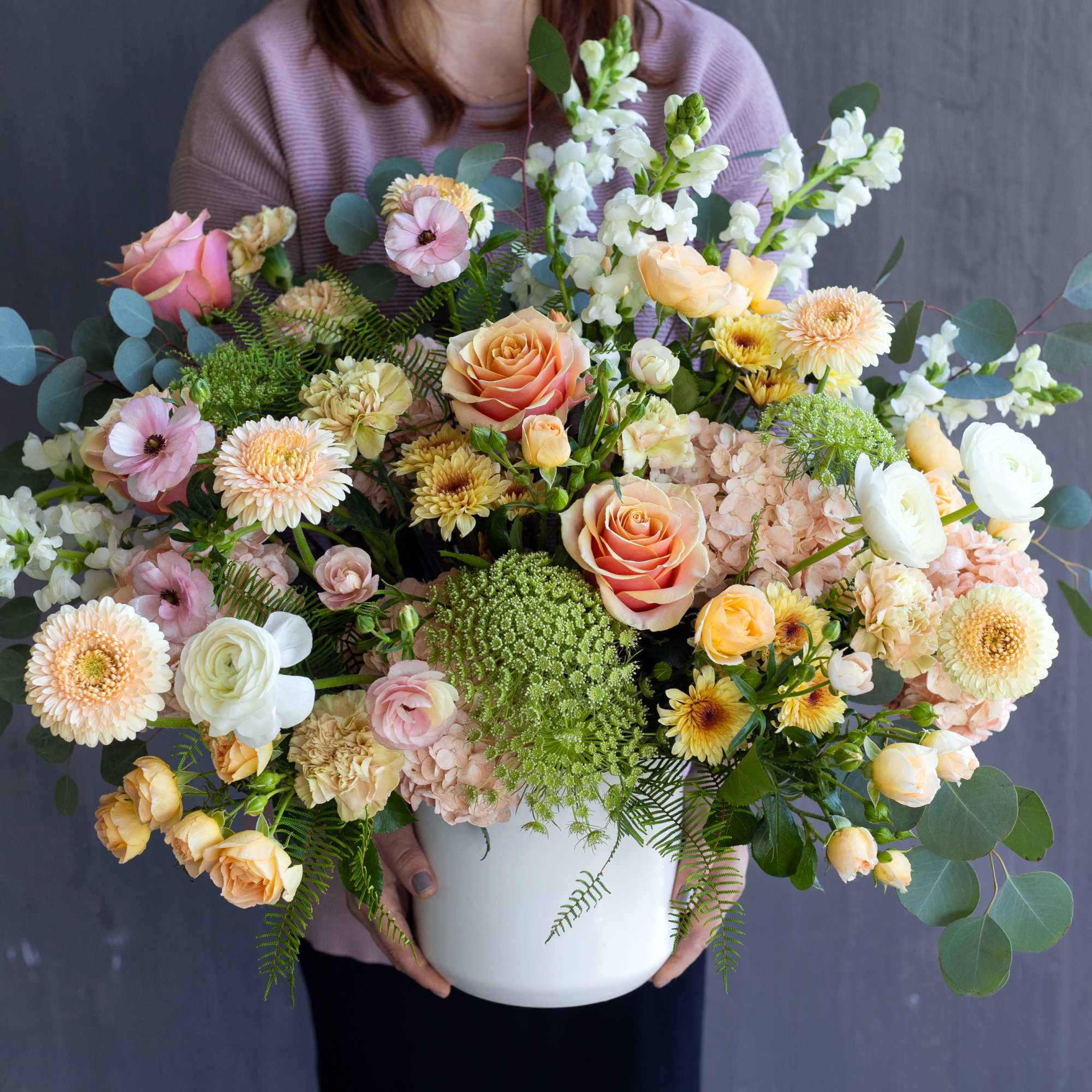 Large pastel flower arrangement in a white vase