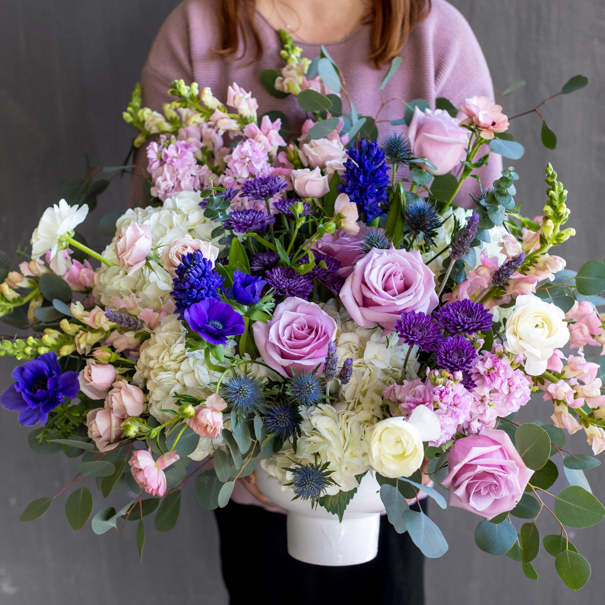 Large mixed bouquet in a white vase with pink, white, and purple flowers