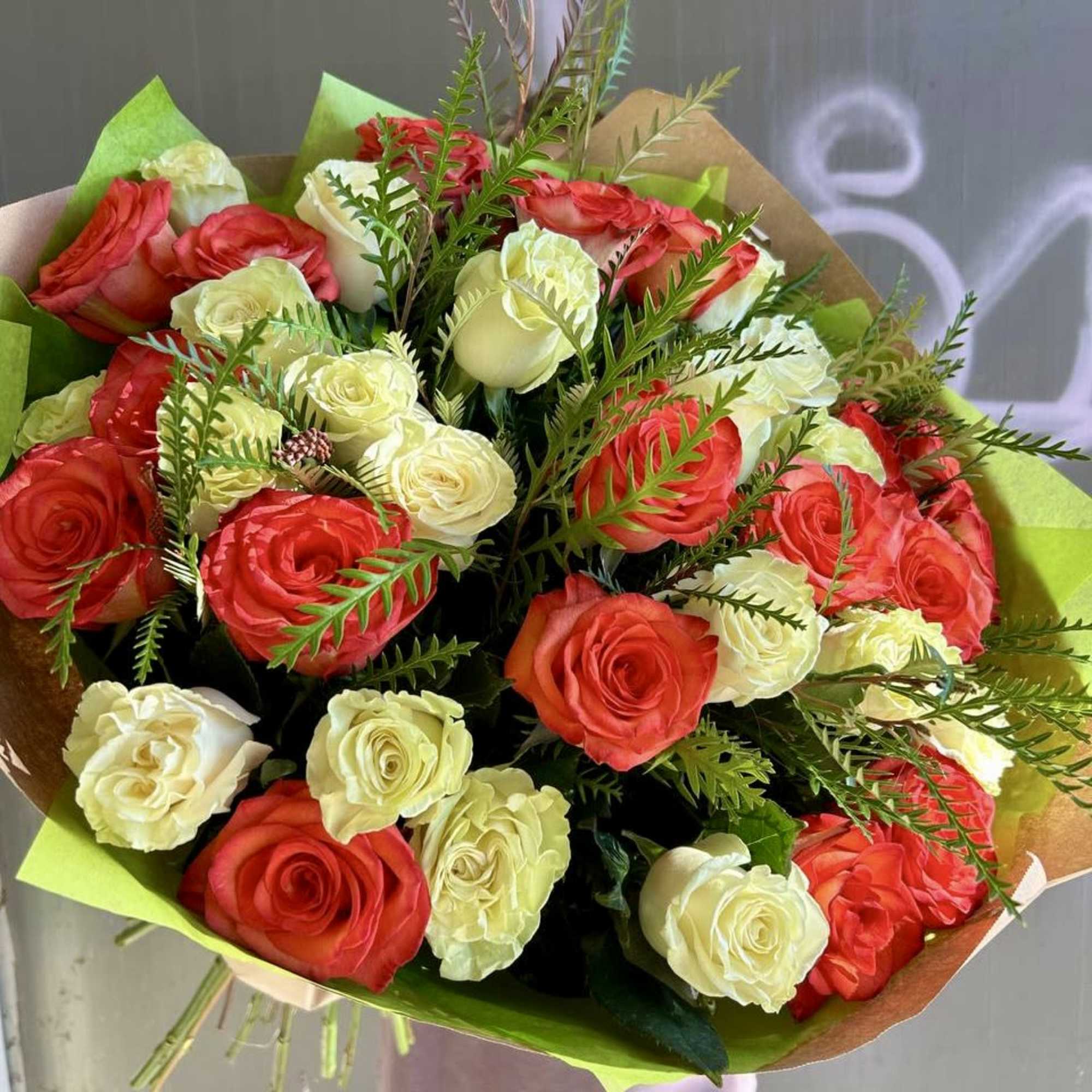 Bouquet of red and white roses wrapped in green paper