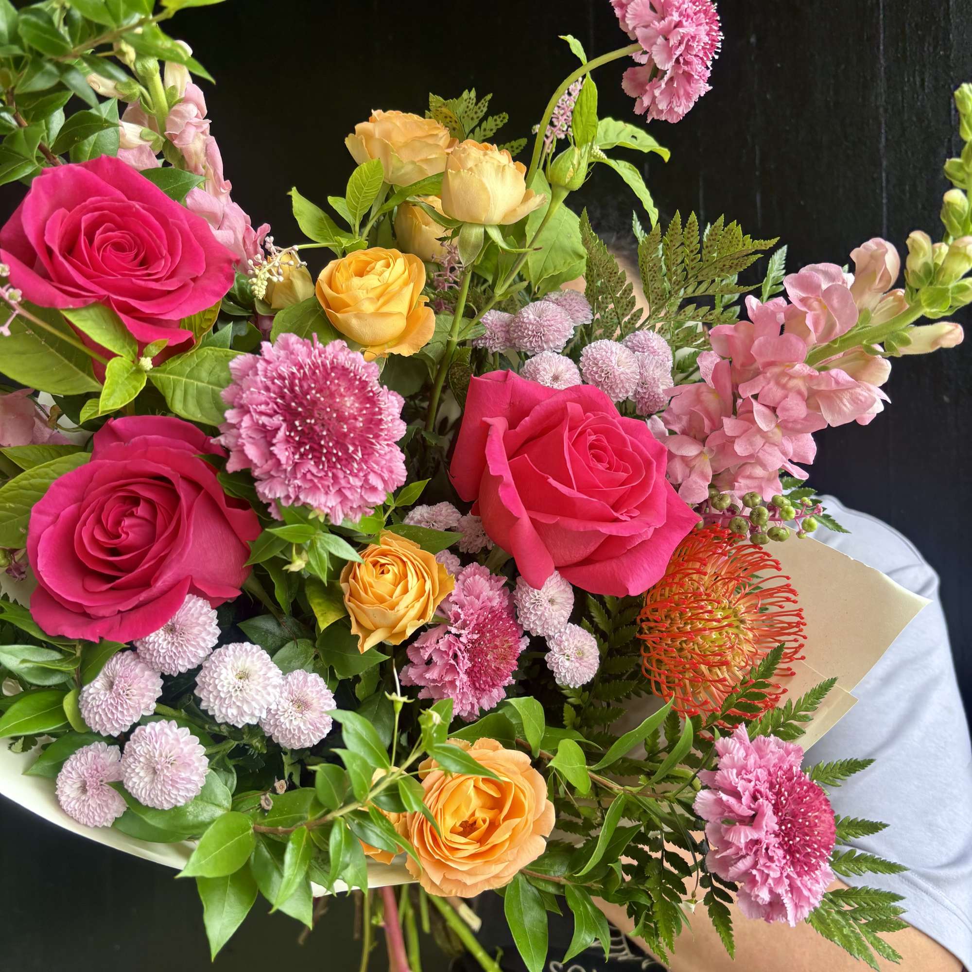 Mixed bouquet of pink and orange roses with pink filler flowers