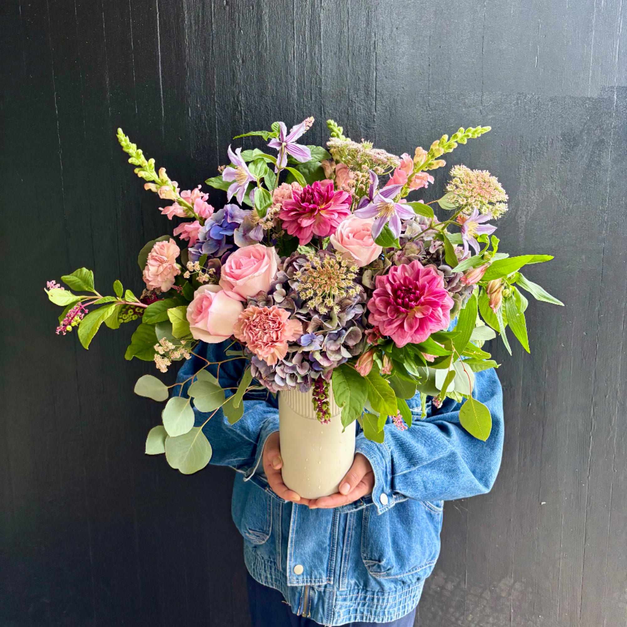 Large mixed bouquet in a cream vase with pink and purple flowers