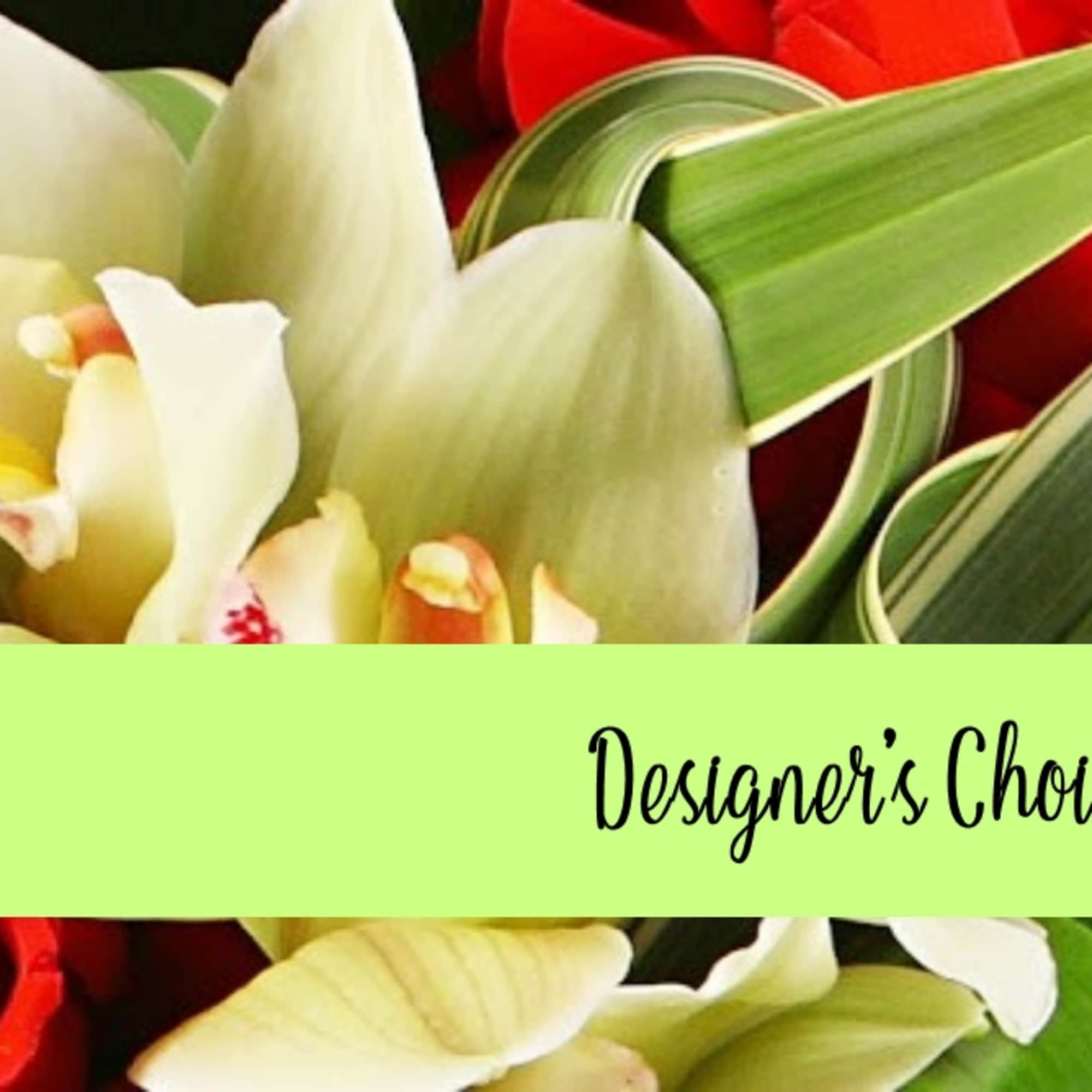 Close-up of white orchids and red roses with a green band reading “Designer’s Choice” across the center.
