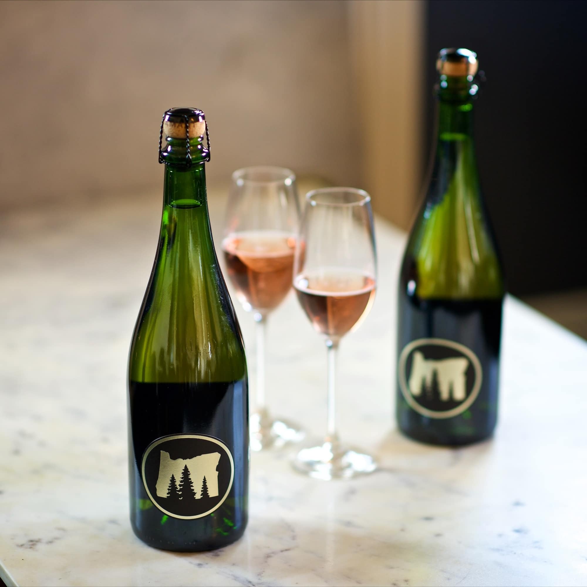 Two sparkling wine bottles with two filled flutes on a table
