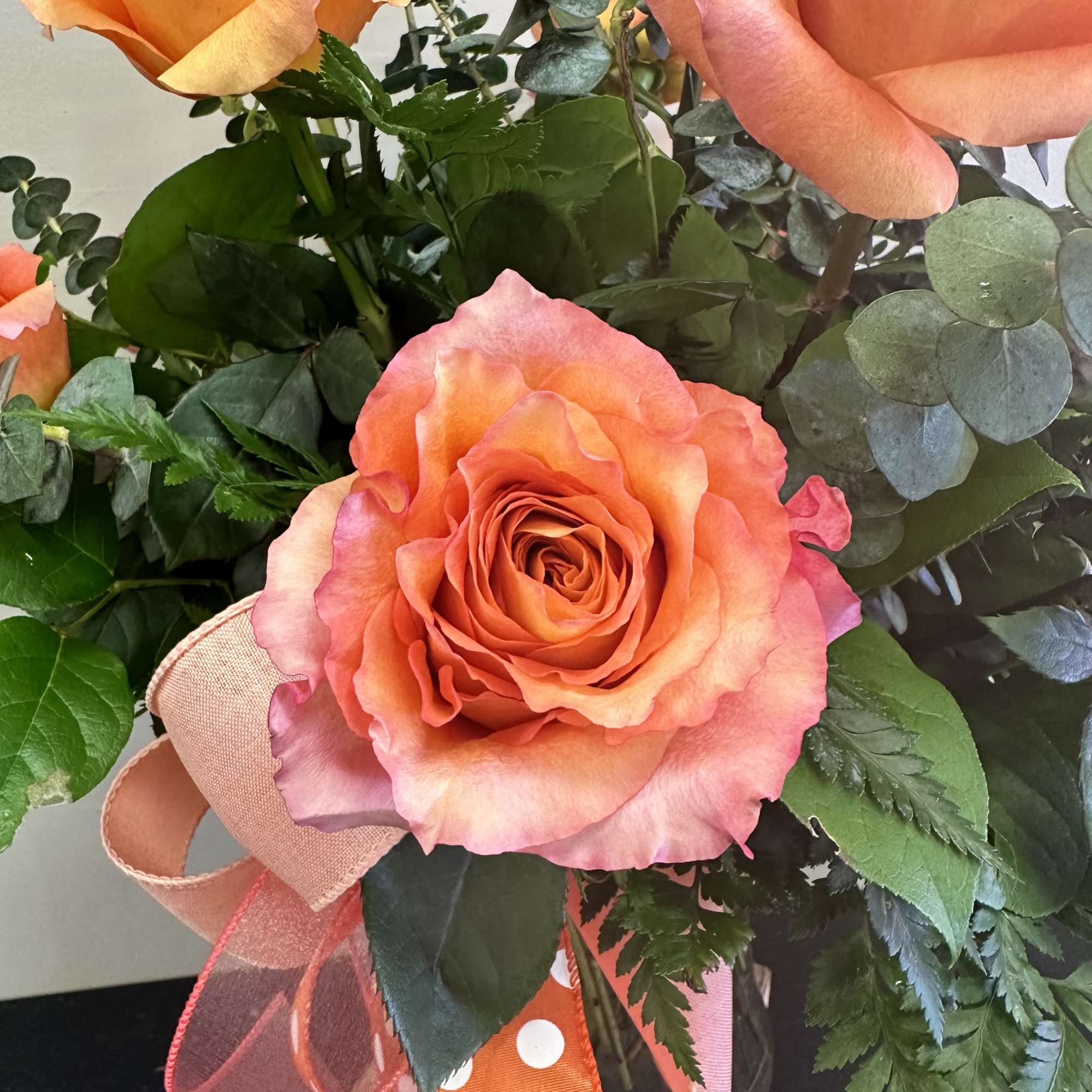 Bouquet of orange-pink roses with eucalyptus and ribbon