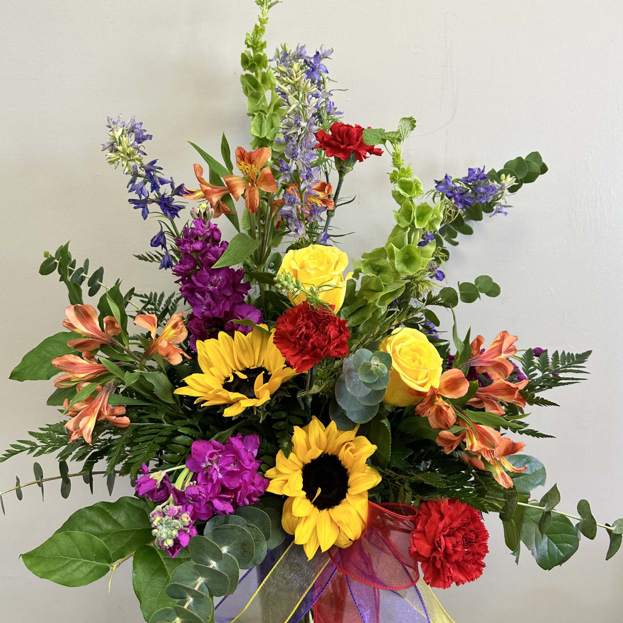 The perfect bright floral arrangement filled with sunflowers, stock, larkspur, alstroemeria and, photo 2 of 2