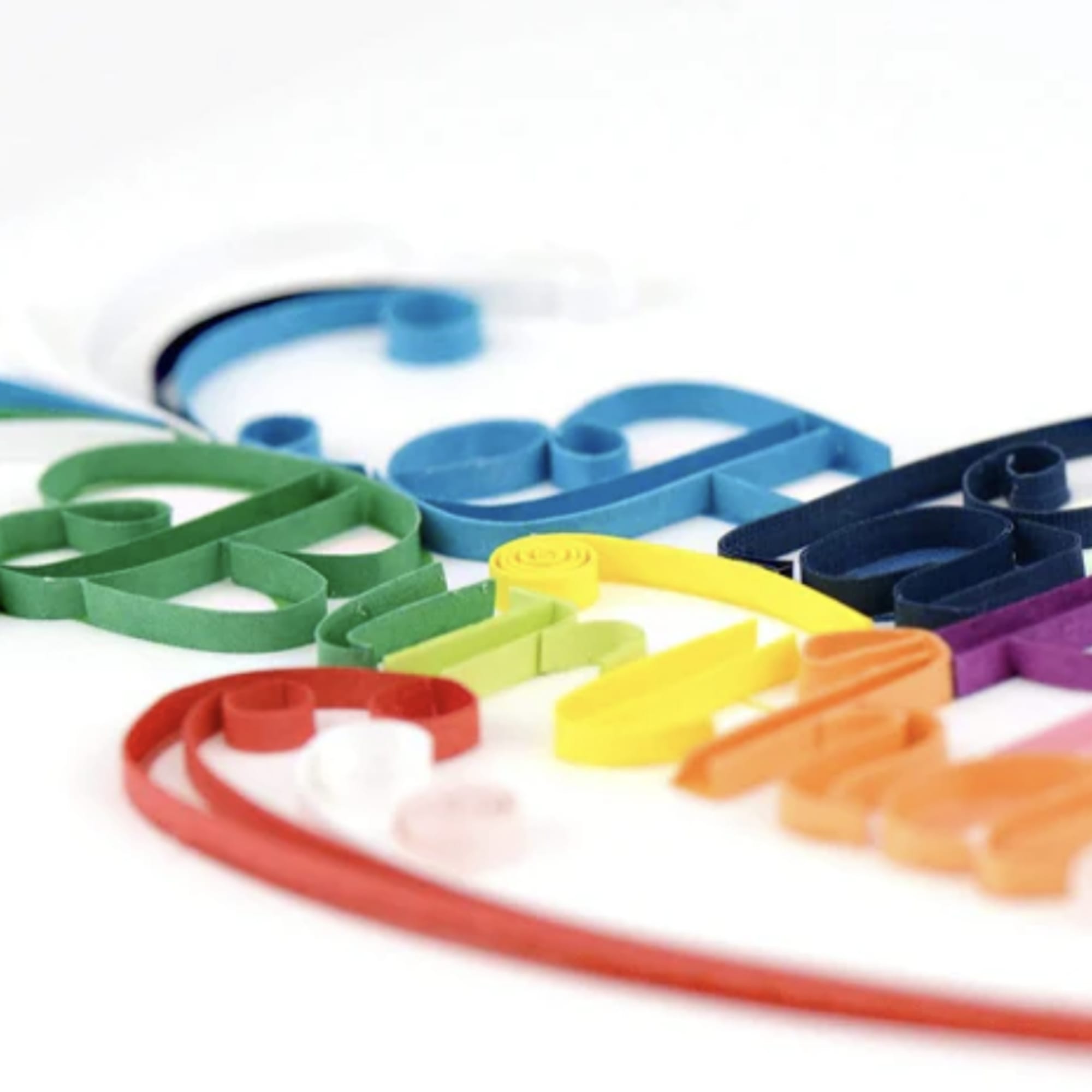 Colorful paper strips arranged on a white surface