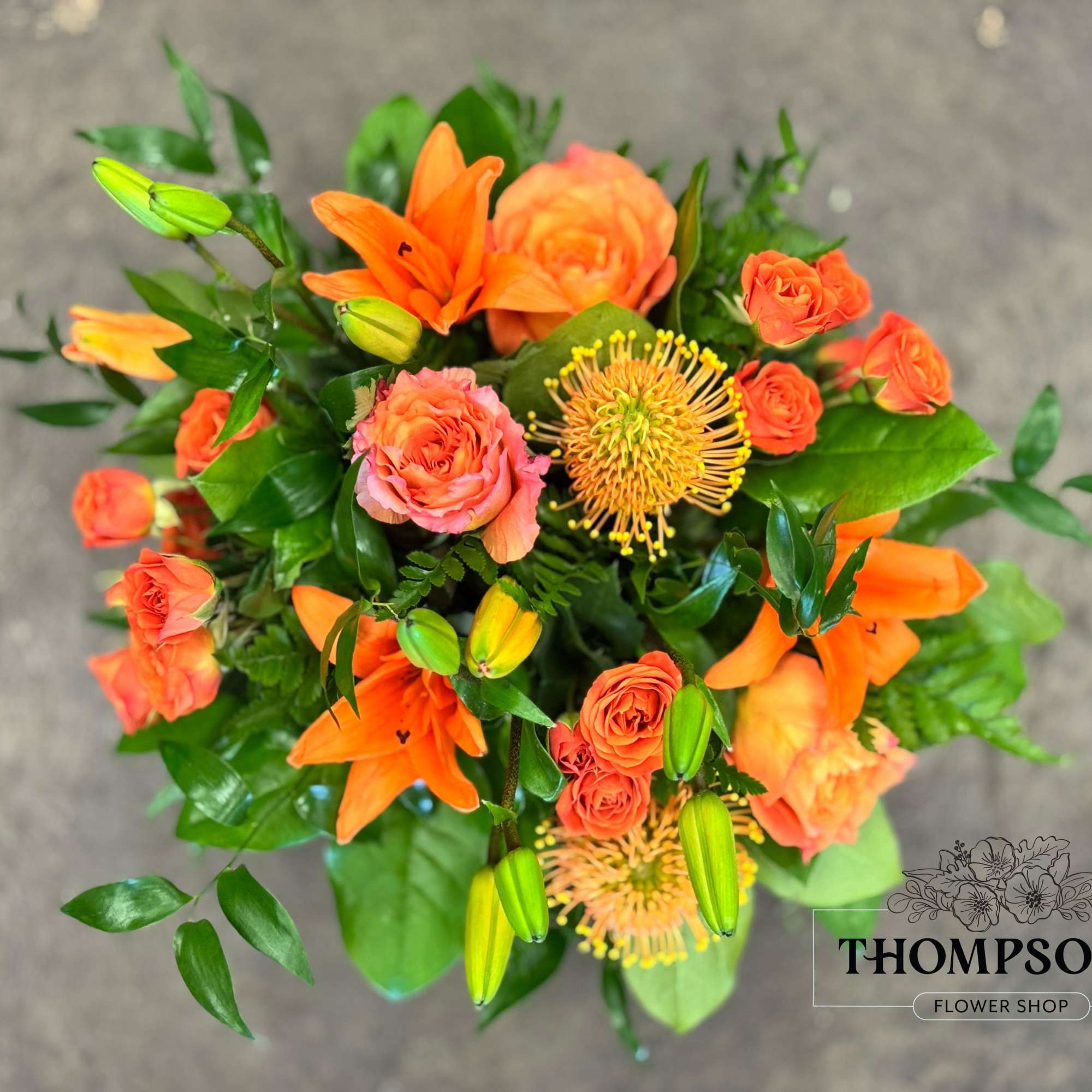 A monochromatic mix of oranges that includes pin-cushion protea, free spirit roses, photo 2 of 5