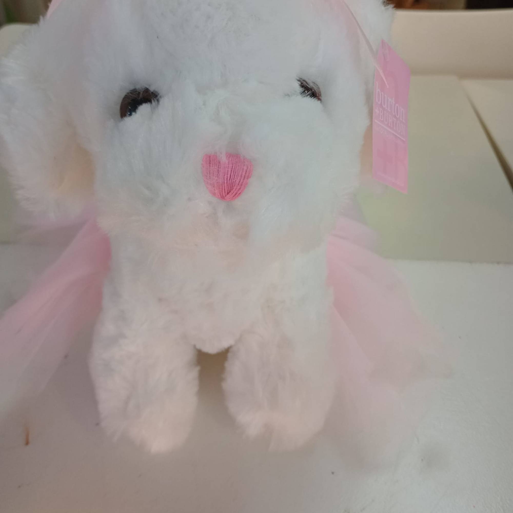 White plush bunny with pink ribbon accents and a pink nose