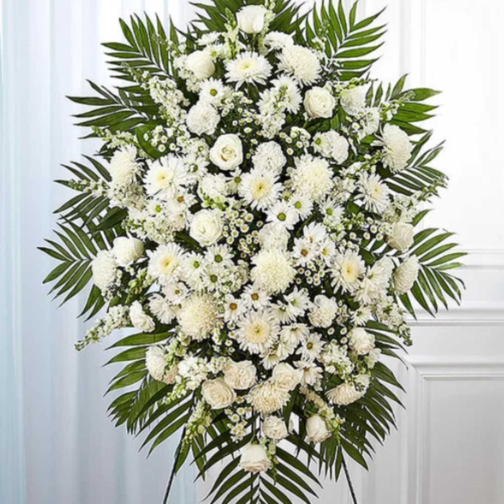 White funeral spray with roses and daisies on a standing easel