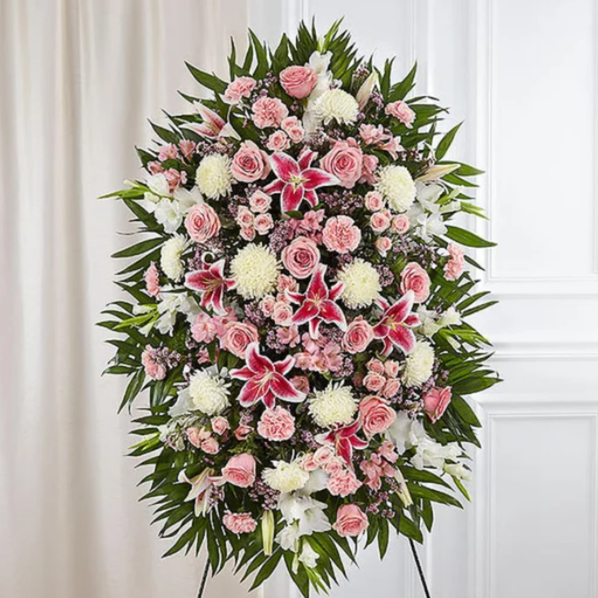 Standing floral spray with pink and white flowers on a black easel
