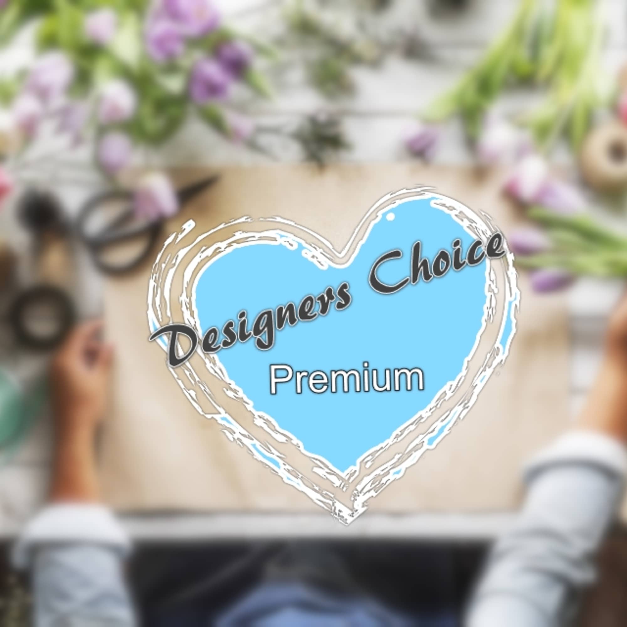 Blurred florist workspace with flowers and wrapping supplies around a "Designers Choice Premium" heart graphic.