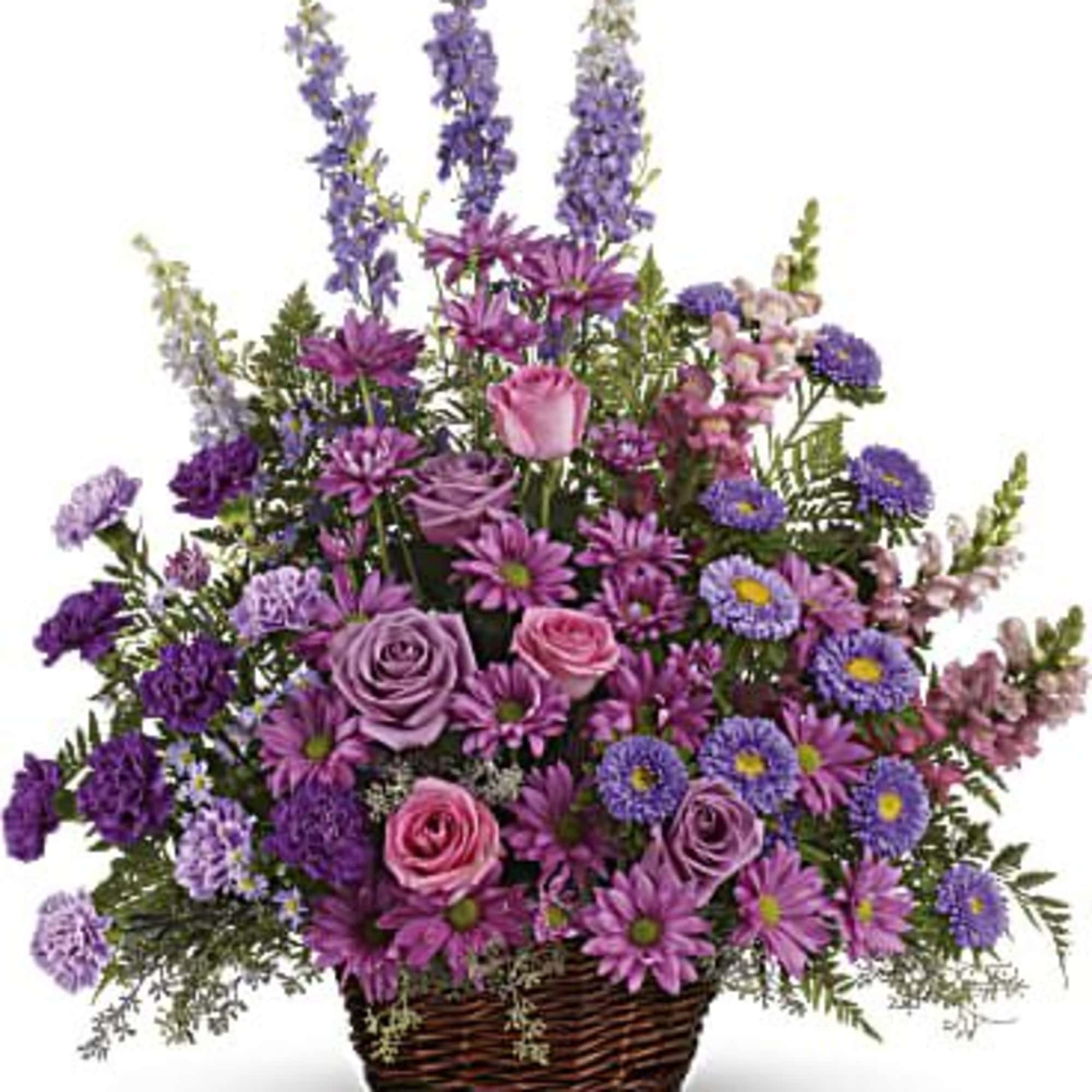 Purple and pink mixed flower arrangement in a wicker basket