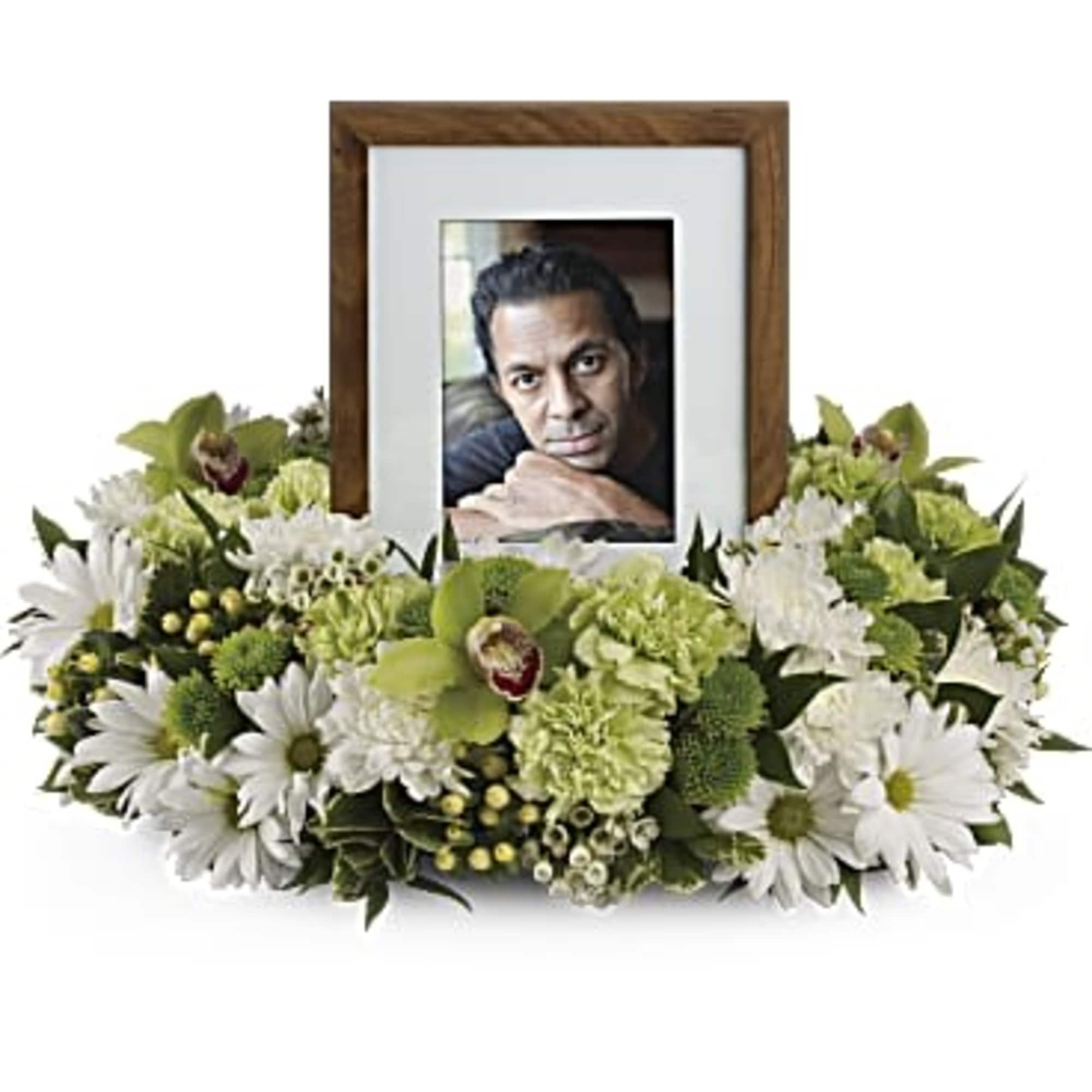White and green floral frame around a photo in a wooden frame