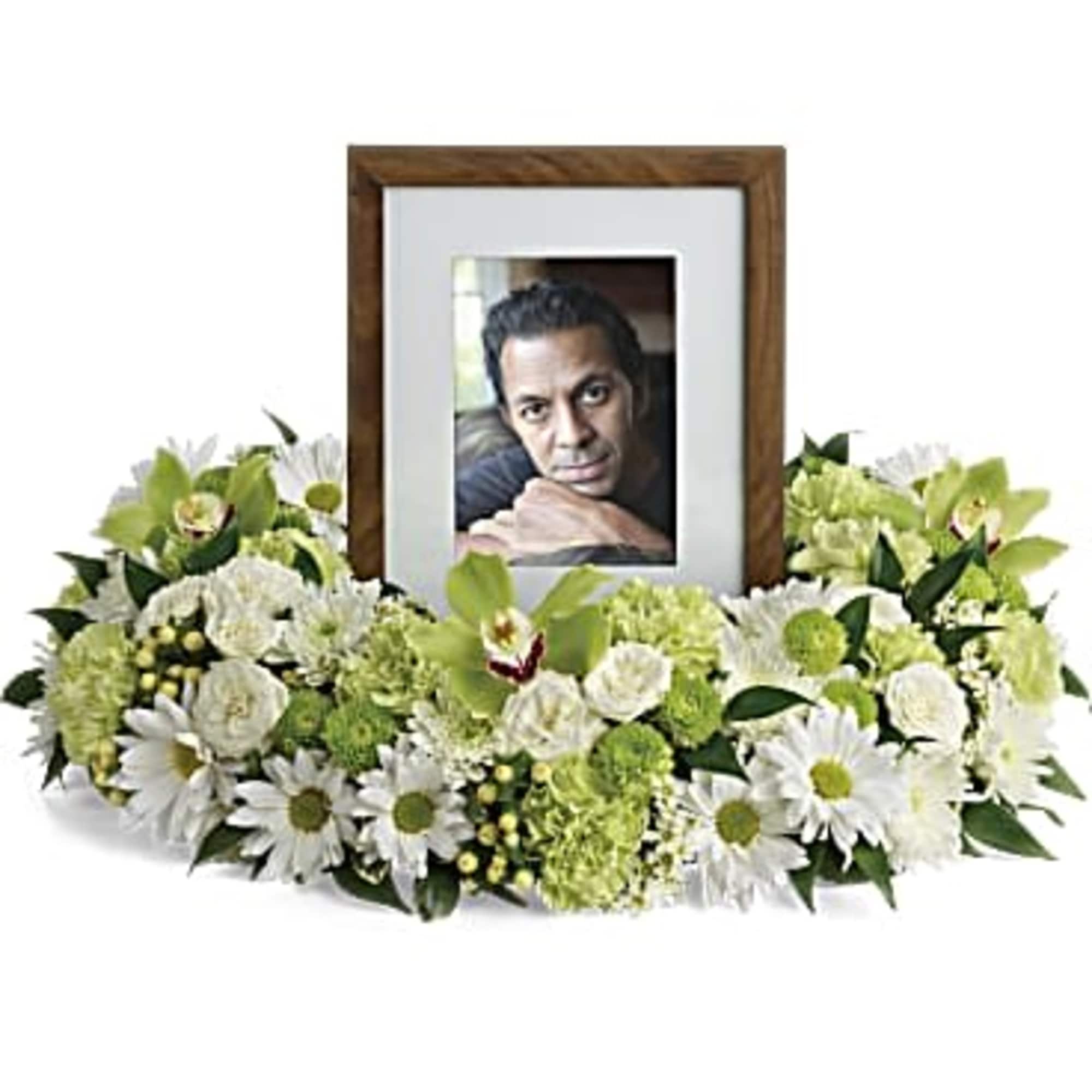 White and green floral arrangement around a framed photo