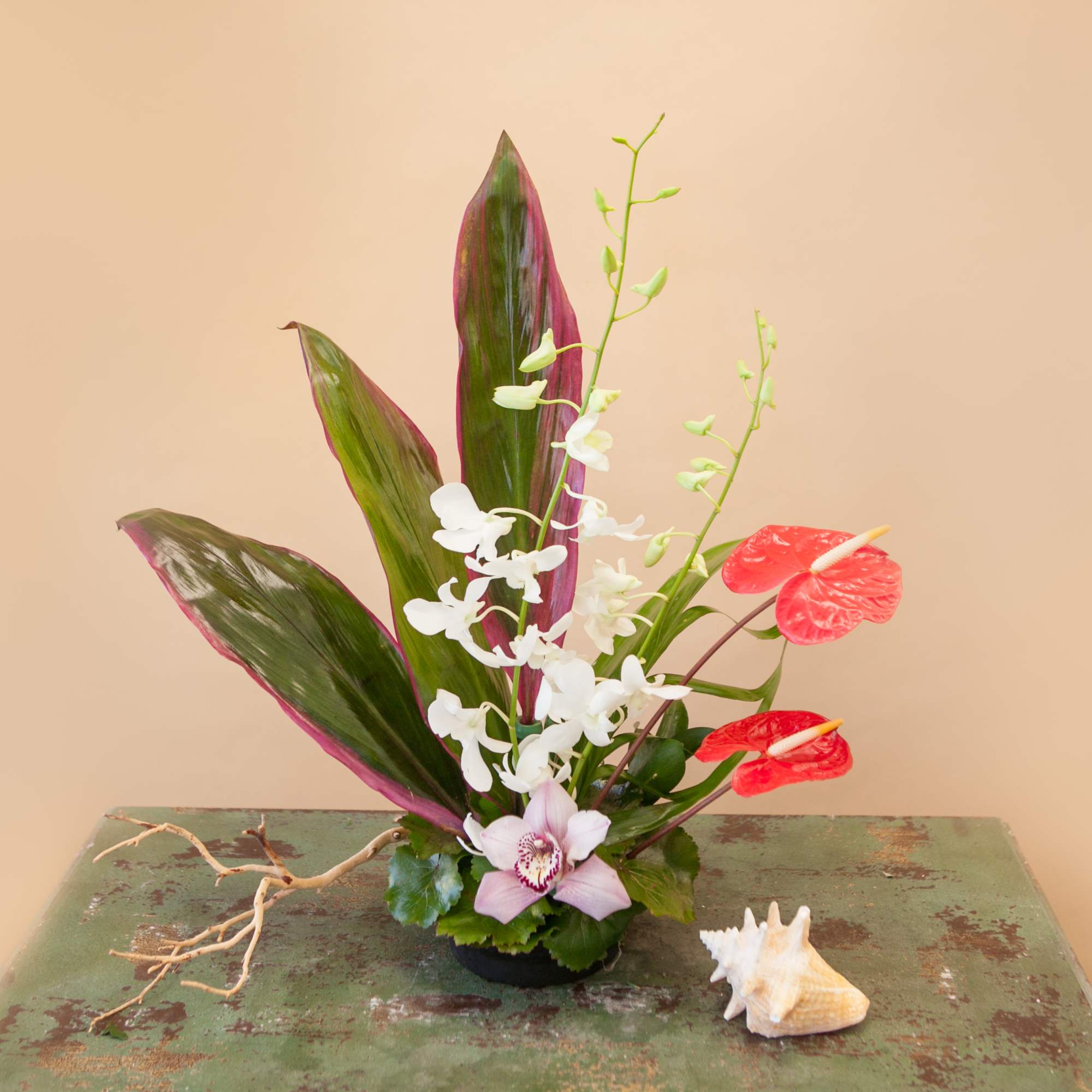 Tropical floral arrangement with white orchids and red anthuriums