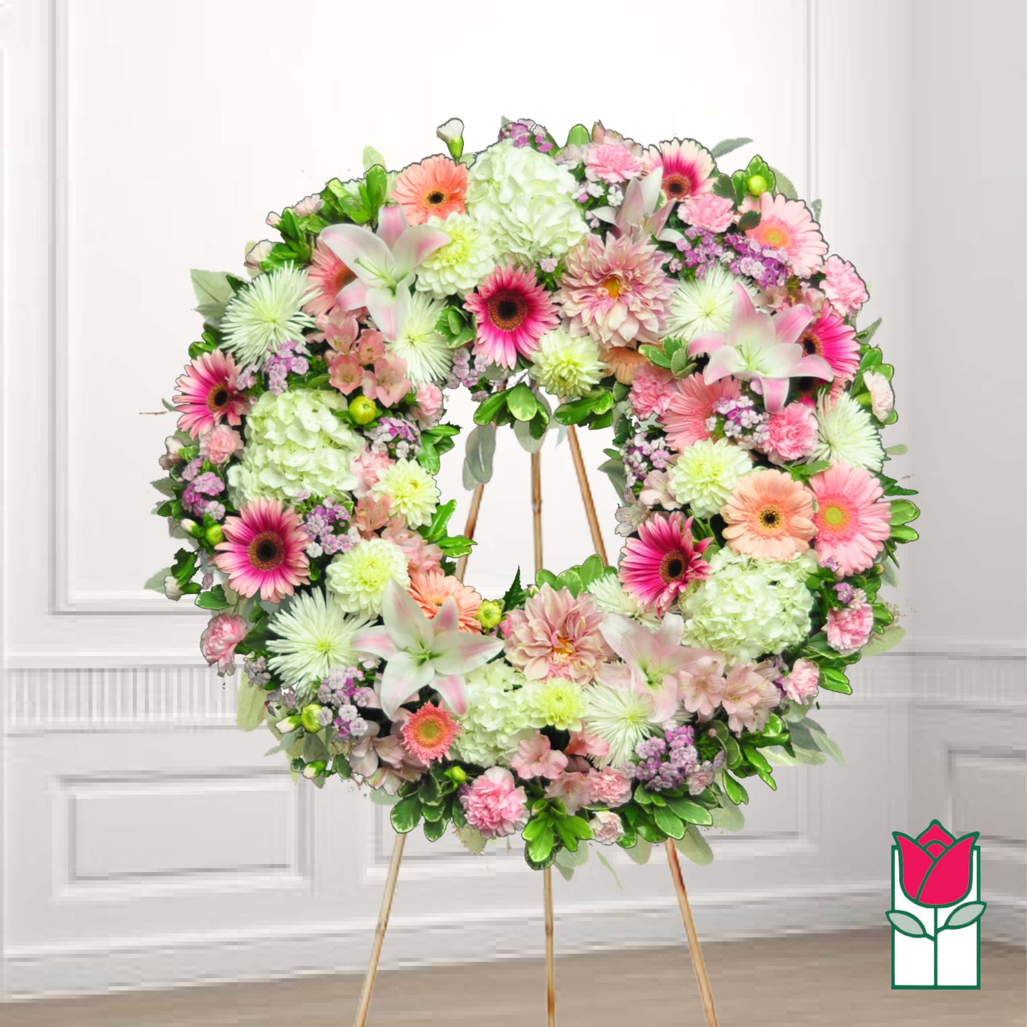 Large floral wreath on a stand with pink, white, and green flowers
