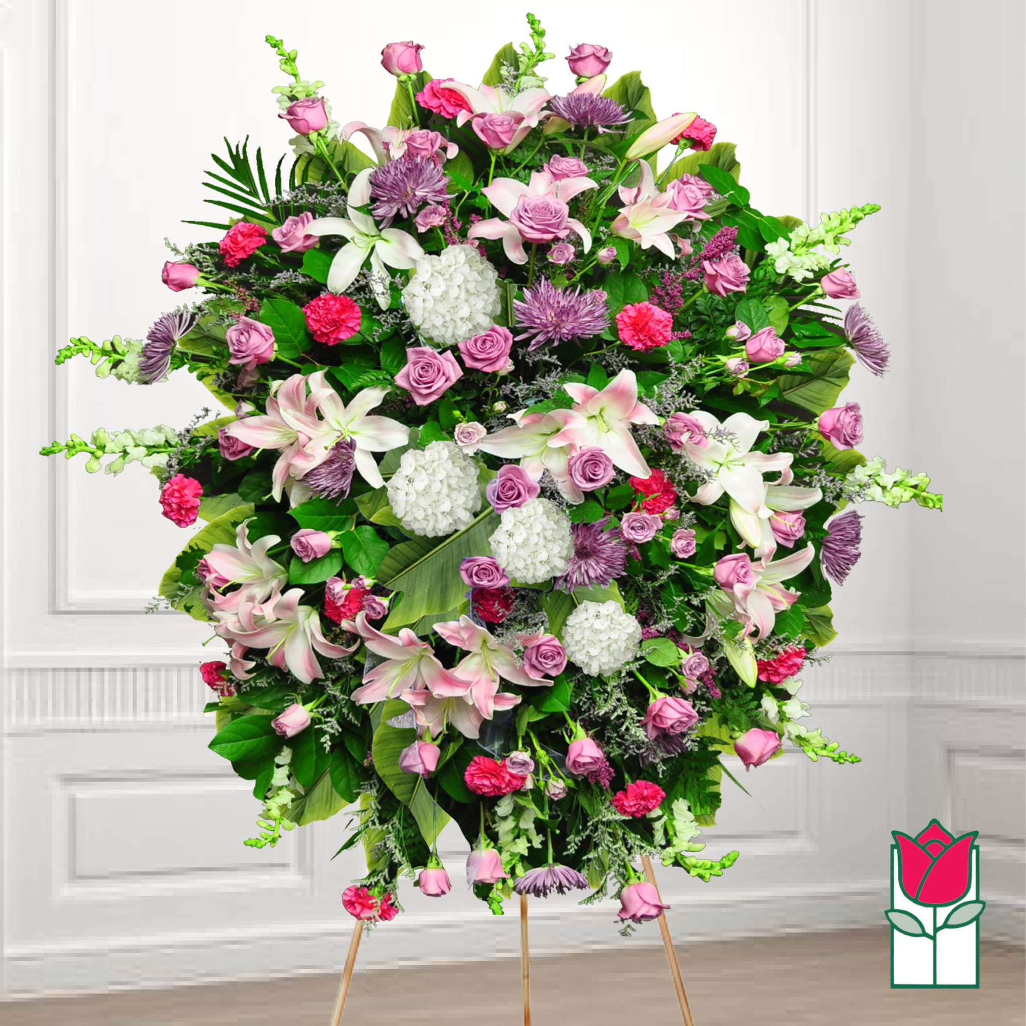 Large standing floral spray with pink and white flowers on a tripod easel