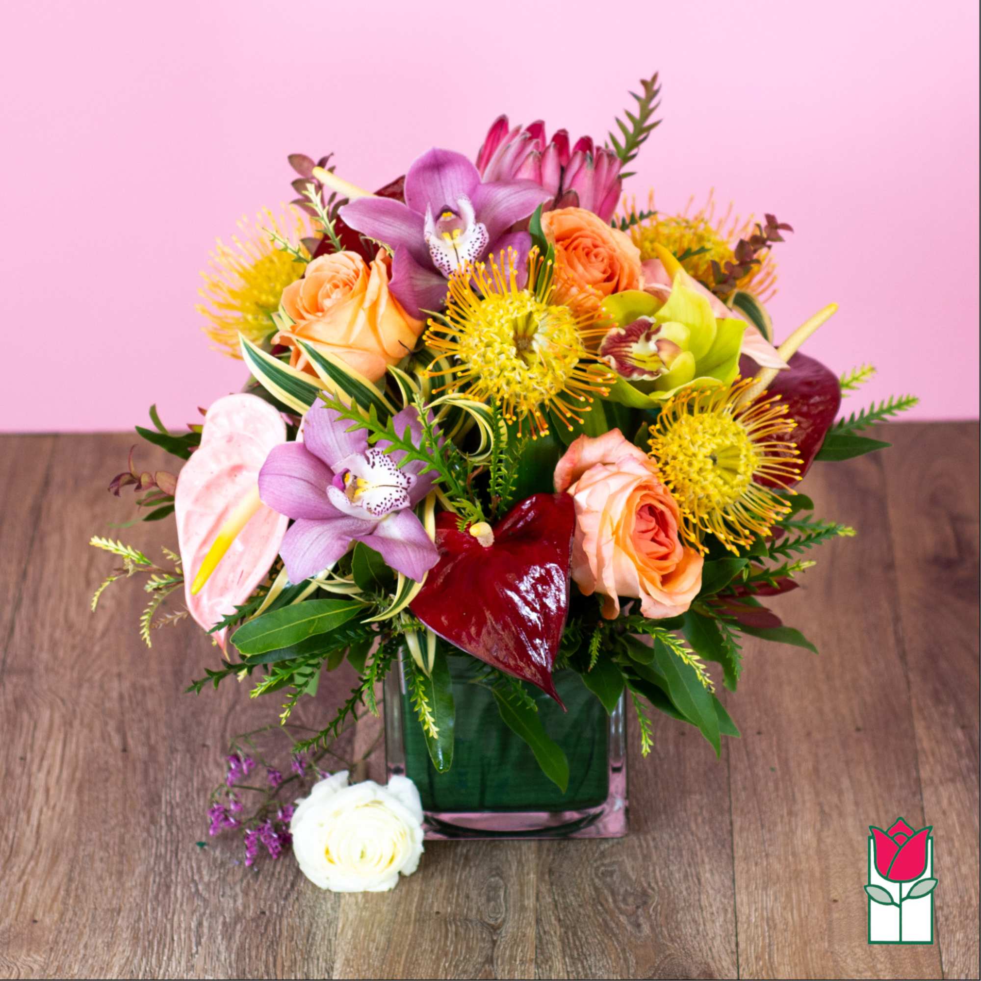 Mixed bouquet in a square glass vase with roses and orchids