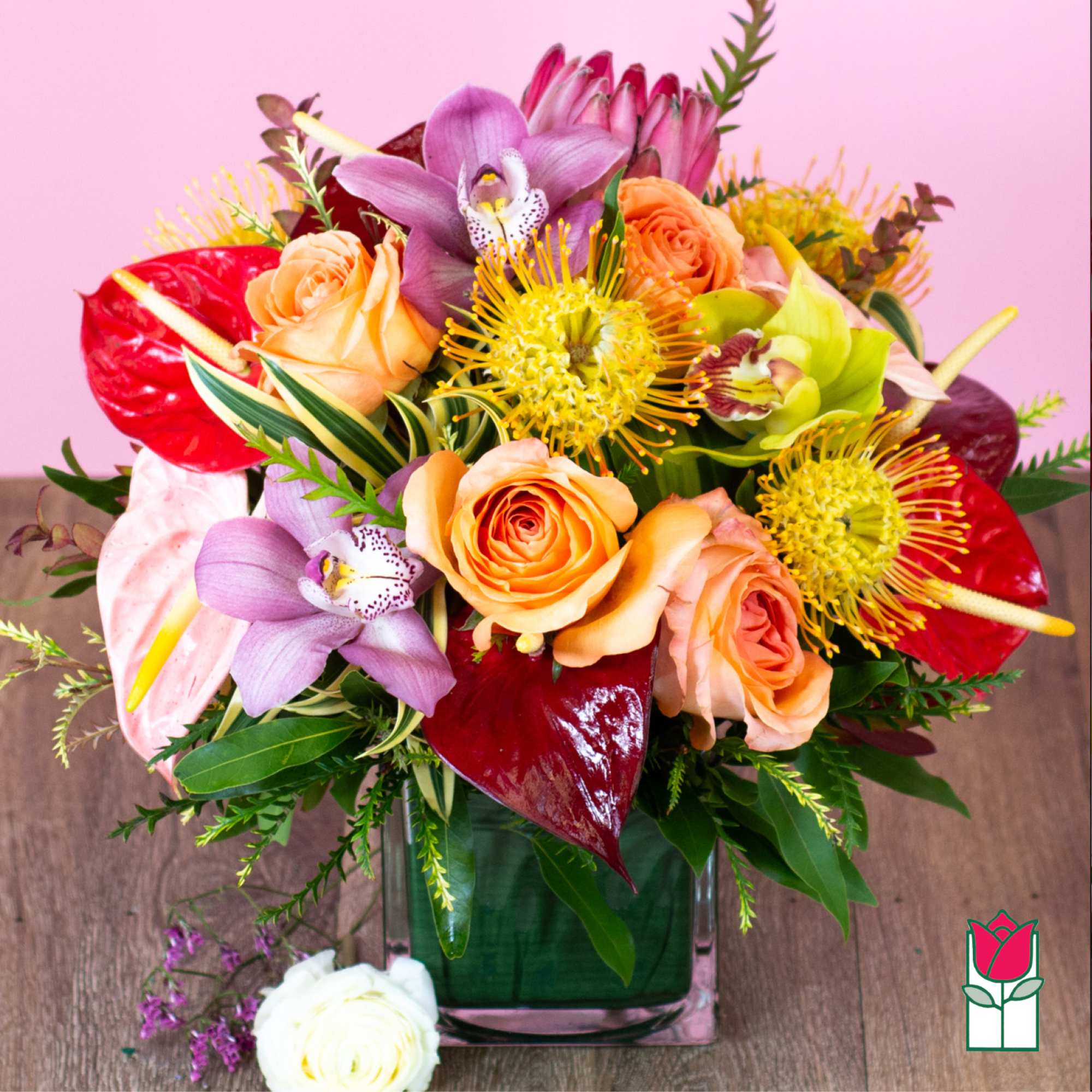 Bouquet of roses, orchids, and anthuriums in a glass vase