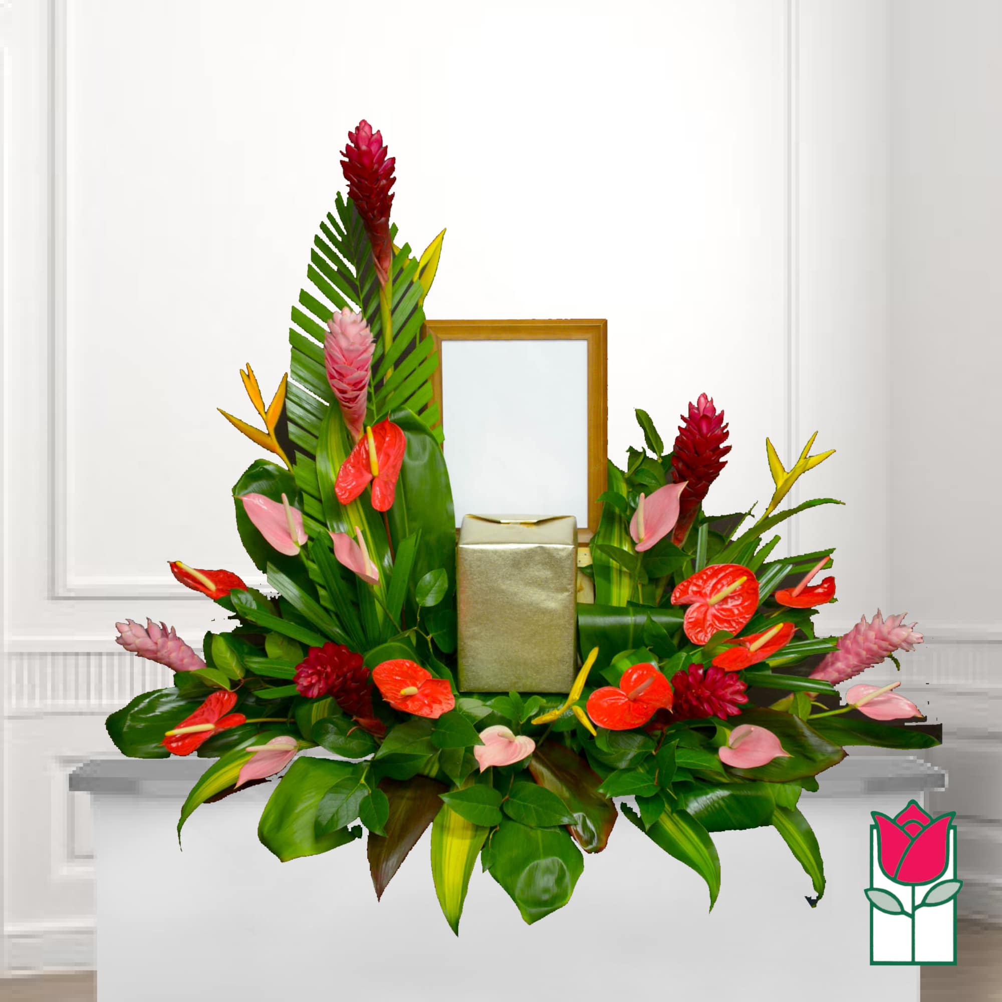 Tropical floral arrangement with red and pink blooms around a gold gift box