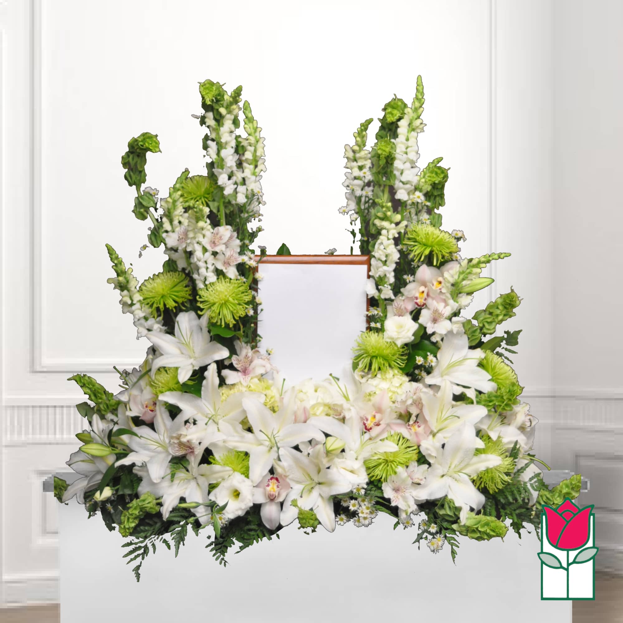 White floral funeral spray with lilies and green accents around a framed center