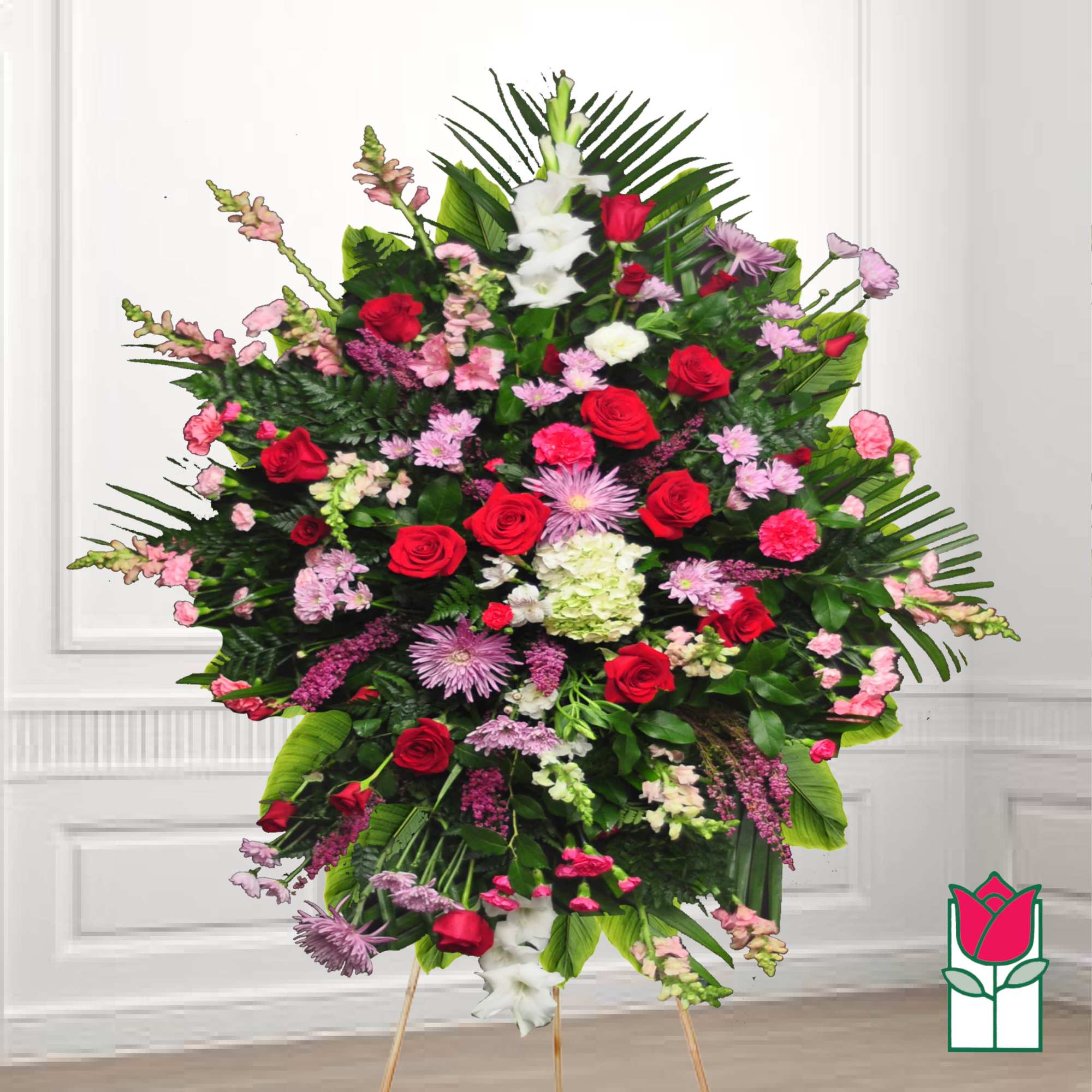 Large standing floral spray with red and pink flowers on an easel