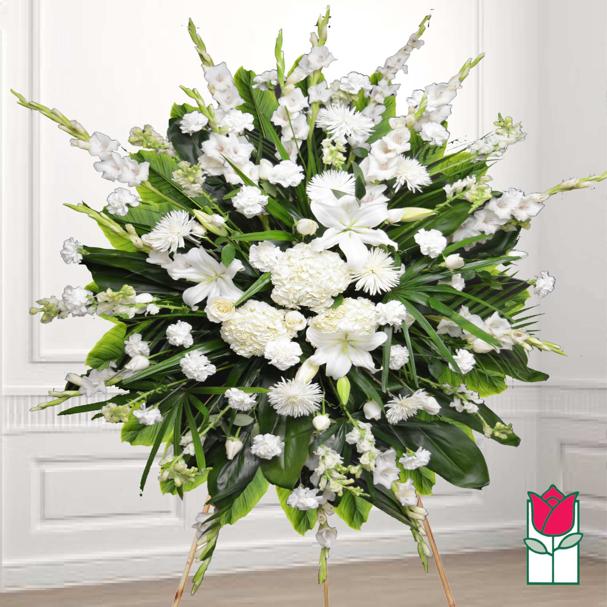 Large white funeral spray on a stand with lilies and chrysanthemums