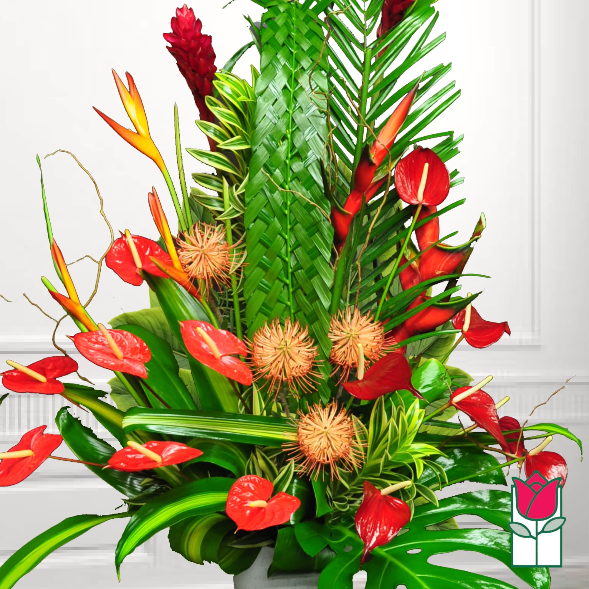 Tropical arrangement with red anthuriums and orange heliconia in a vase