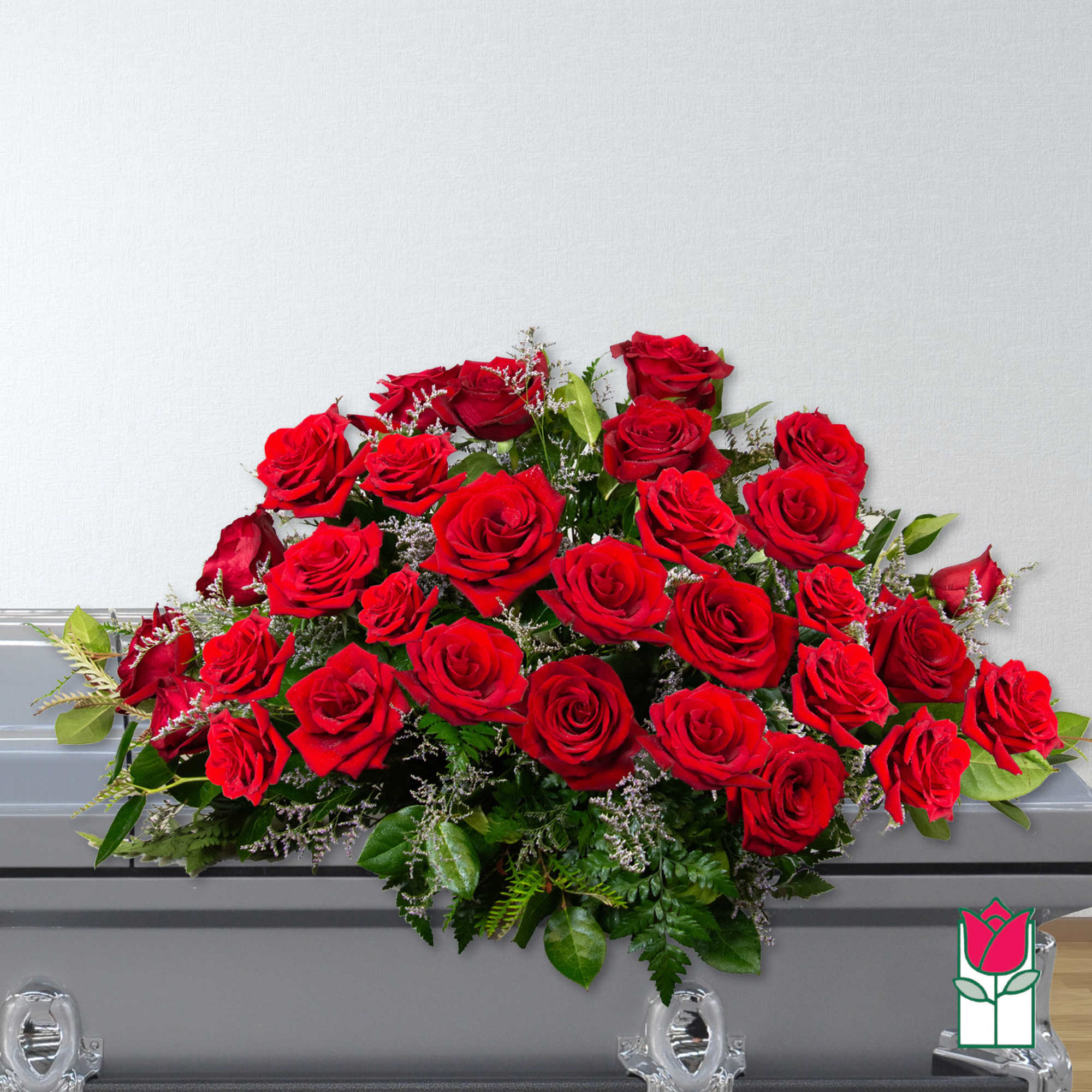 Large red rose casket spray with greenery