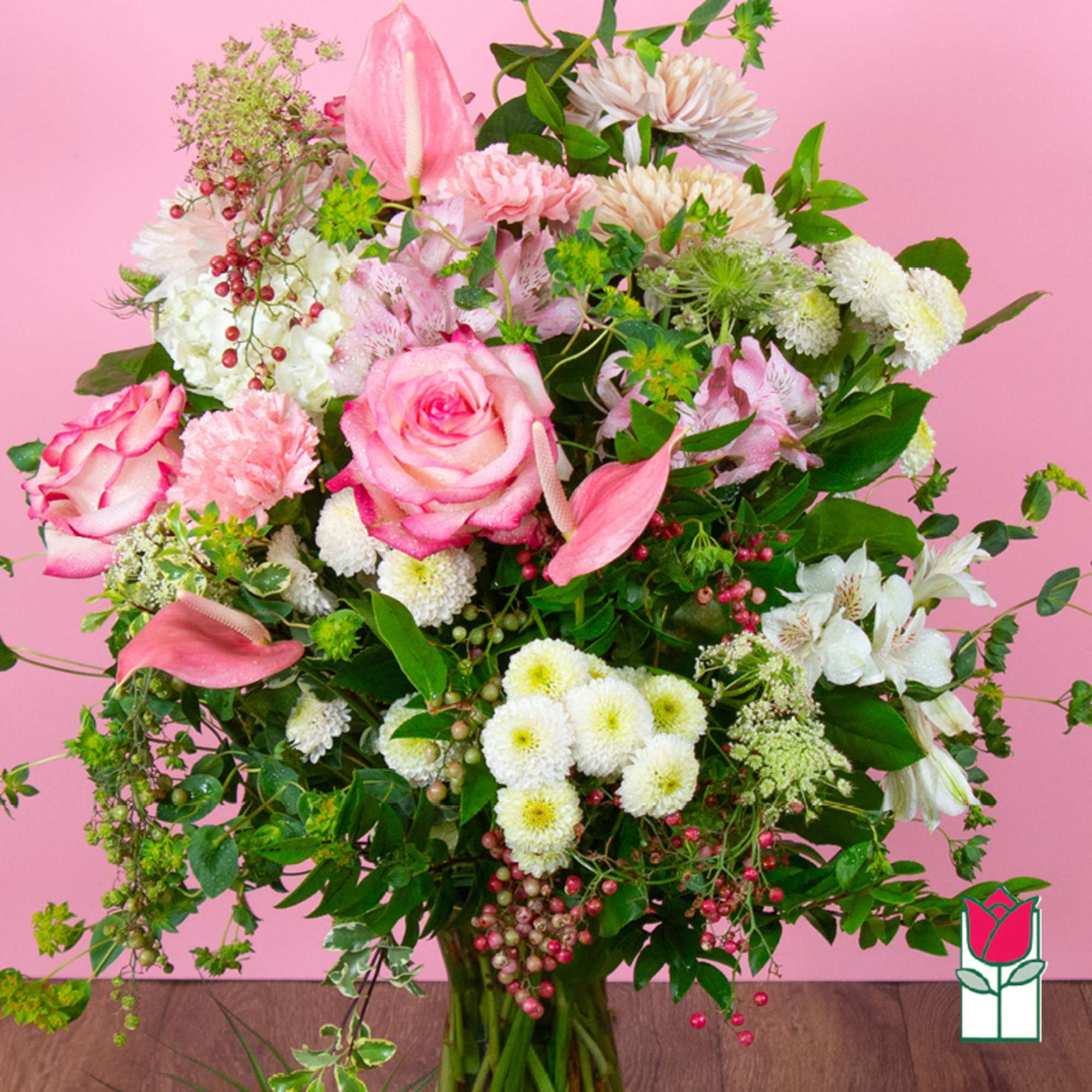 Large pink and white mixed flower arrangement in a glass vase