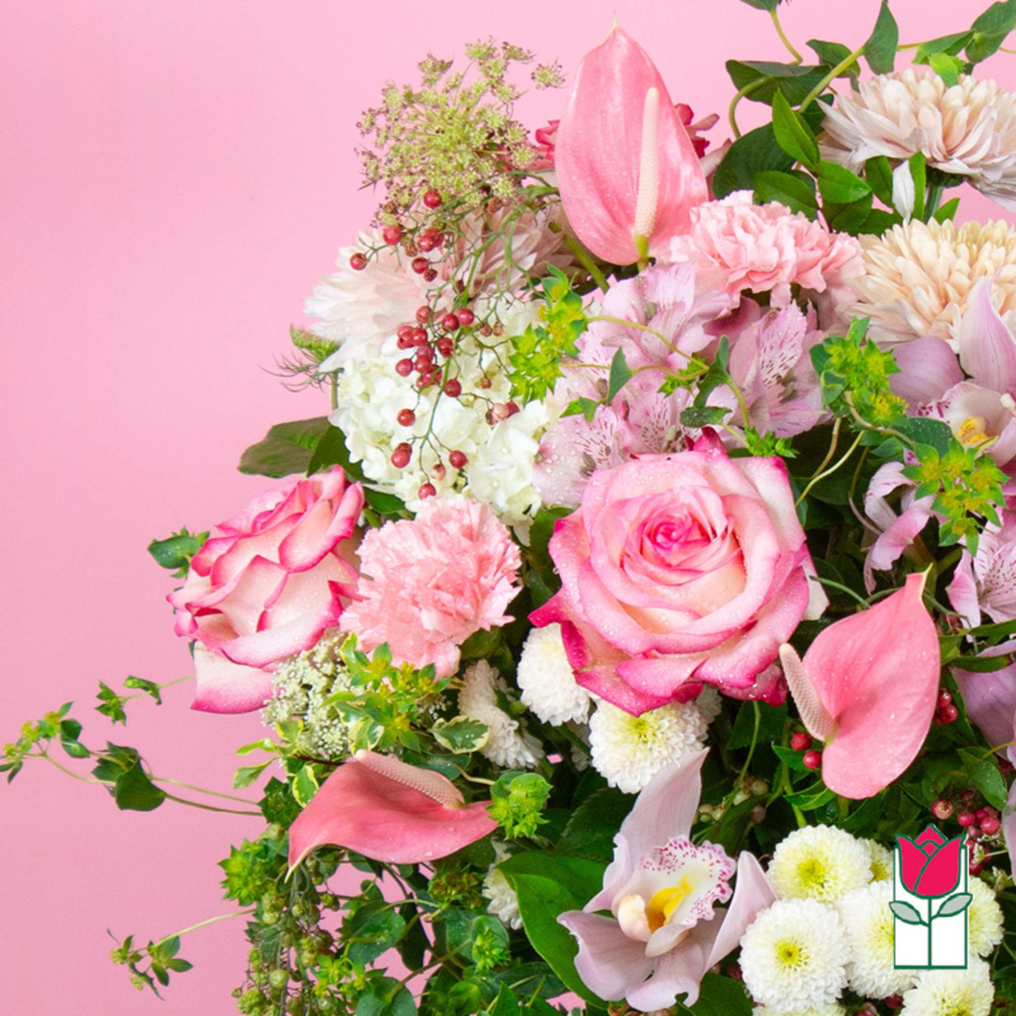 Pink roses and lilies arranged with white blooms against a pink background