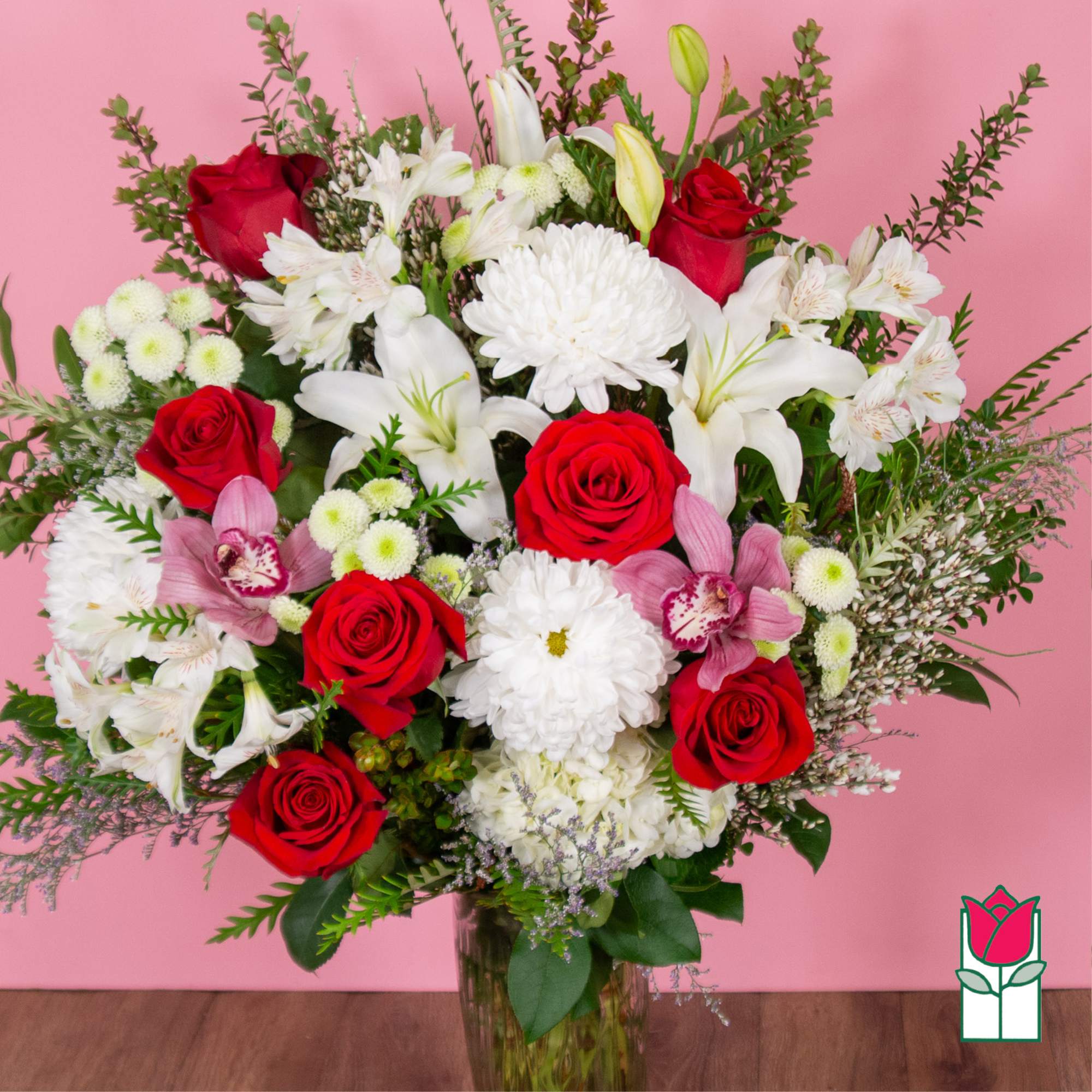 Bouquet of red roses, white lilies, and white chrysanthemums in a glass vase