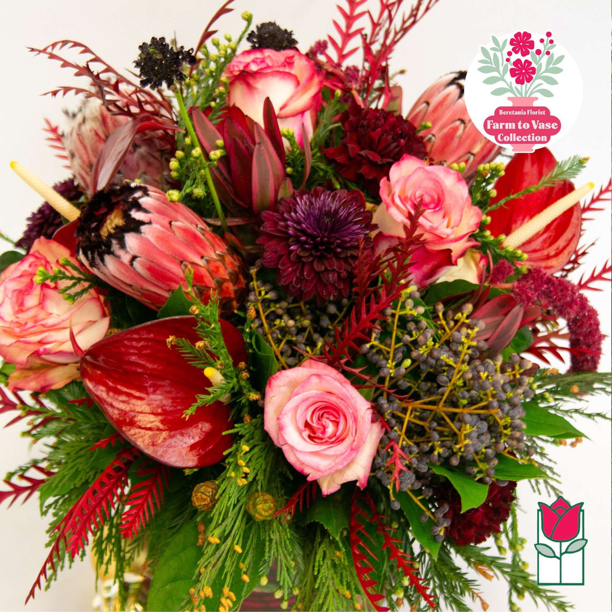 Bouquet of pink roses, burgundy blooms, and red tropical flowers