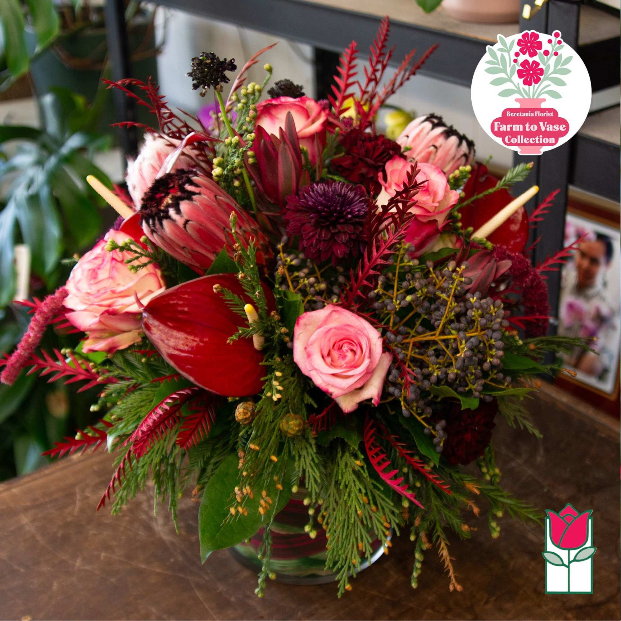 Pink and burgundy floral arrangement in a glass vase