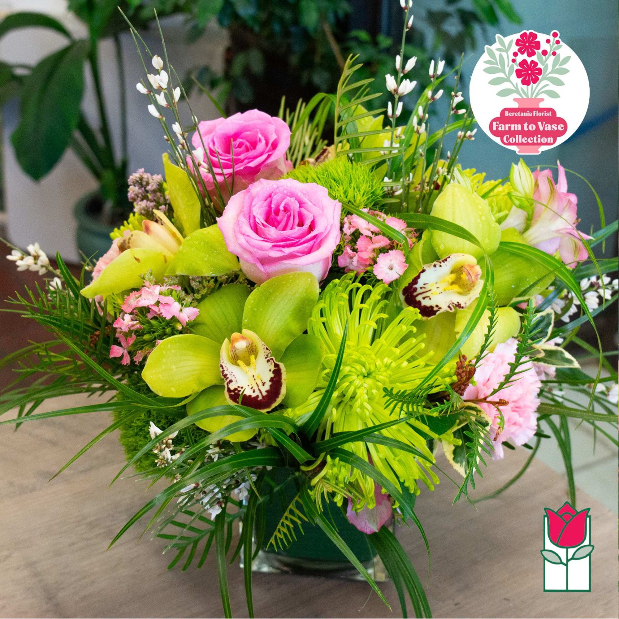 Pink roses and green orchids in a glass vase