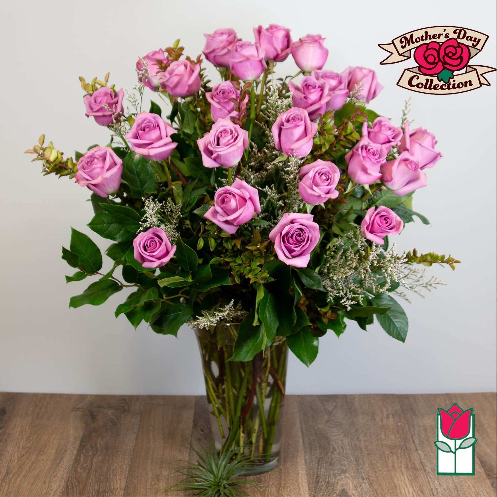 Pink roses arranged in a clear glass vase with greenery