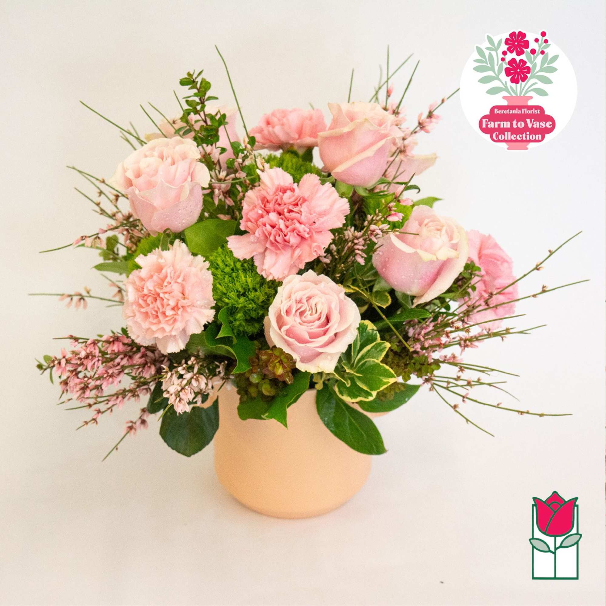 Pink roses and carnations arranged in a pale vase