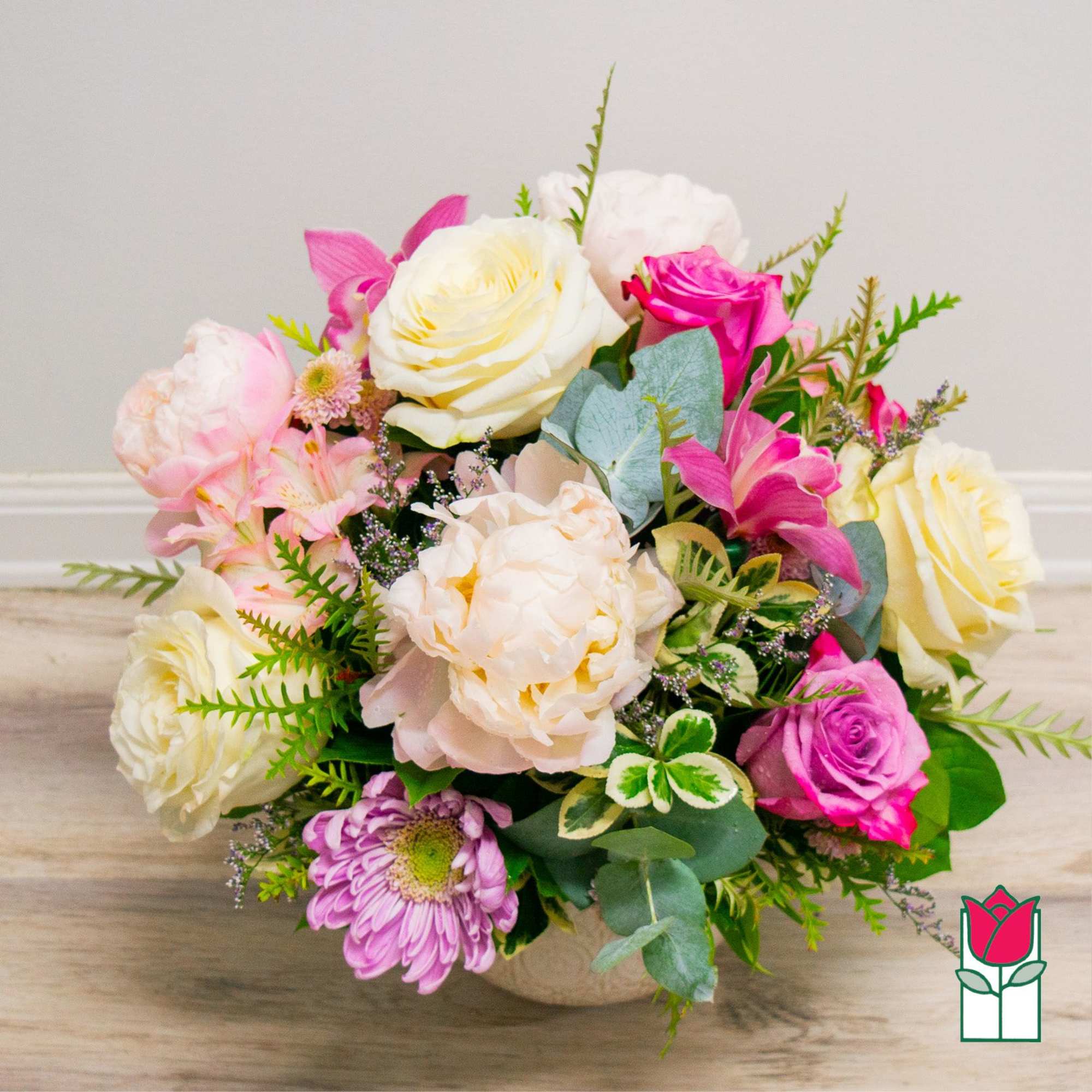 Mixed bouquet of pink, white, and cream flowers in a low vase