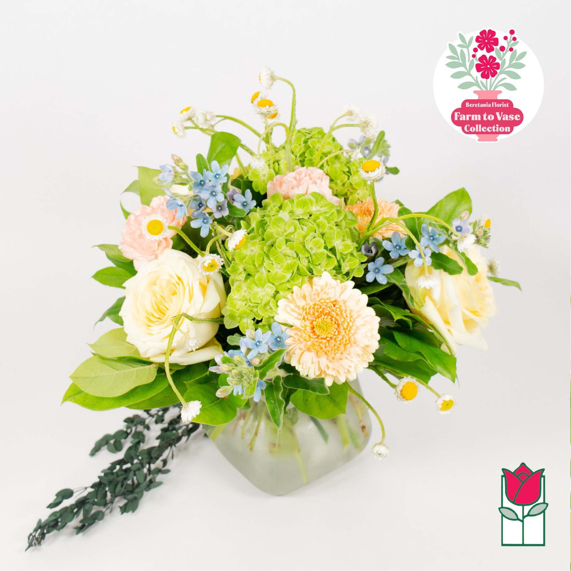 Bouquet of cream, peach, blue, and green flowers in a glass vase