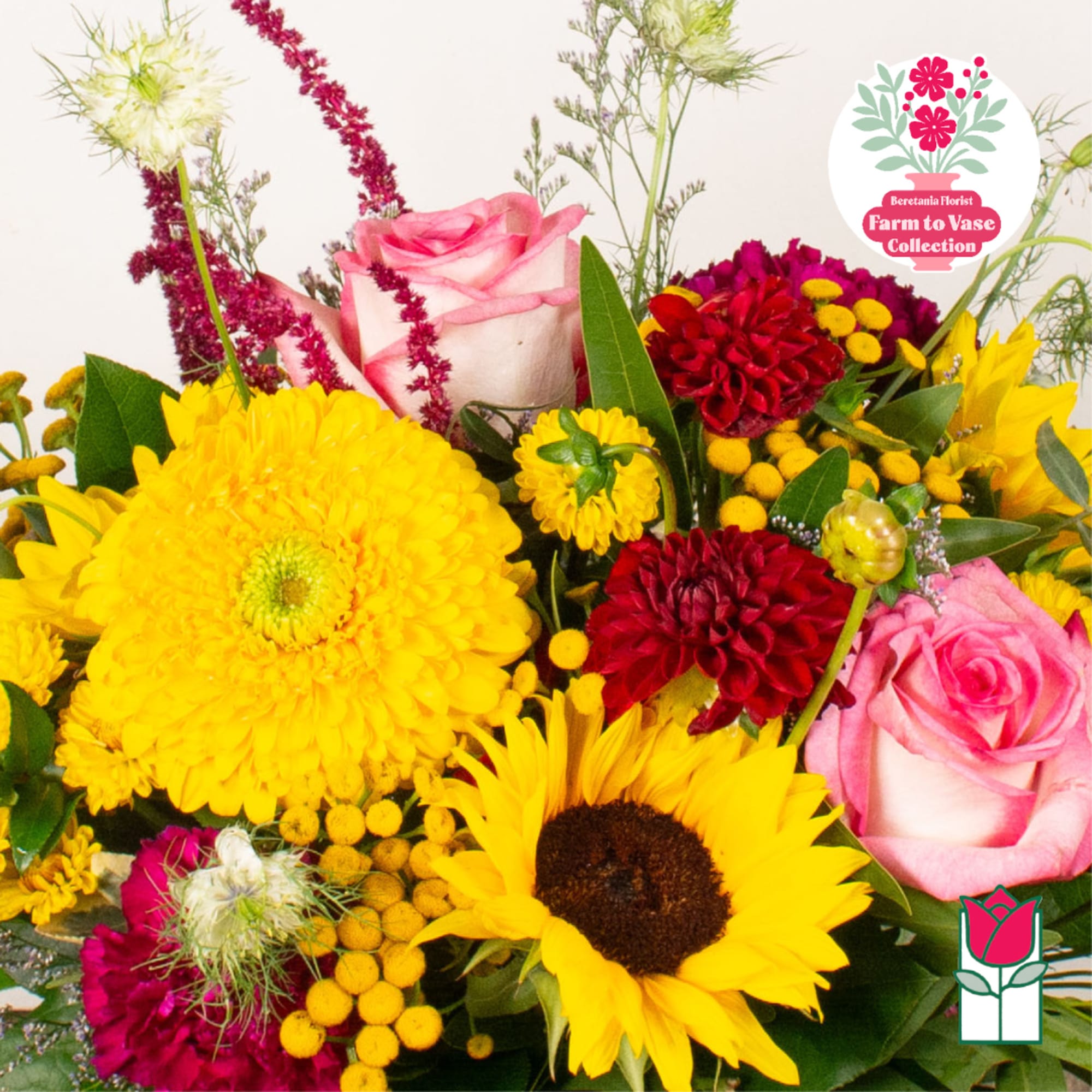 Mixed bouquet with pink roses, yellow sunflowers, and red blooms