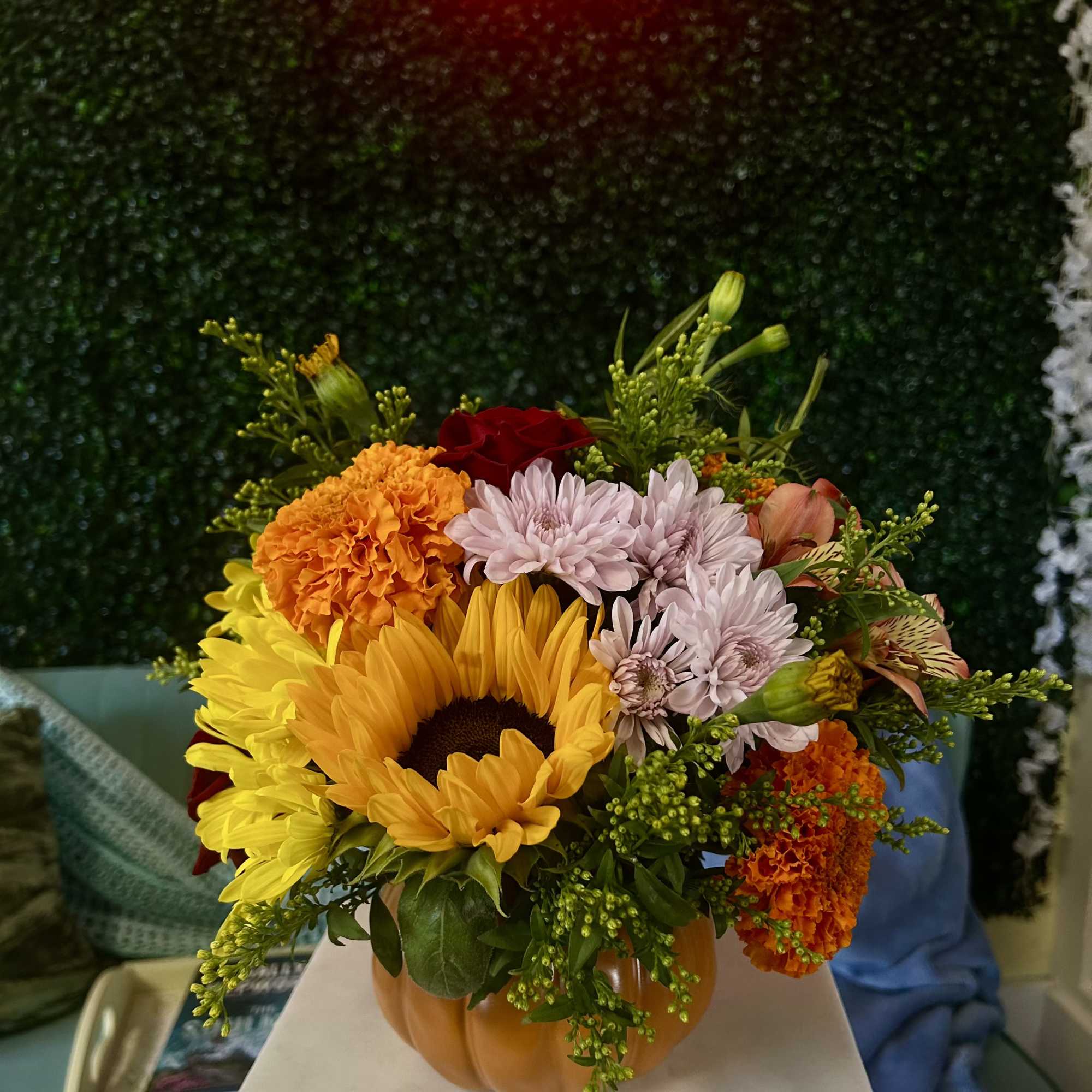Mixed bouquet in a pumpkin-shaped vase with sunflowers and mums