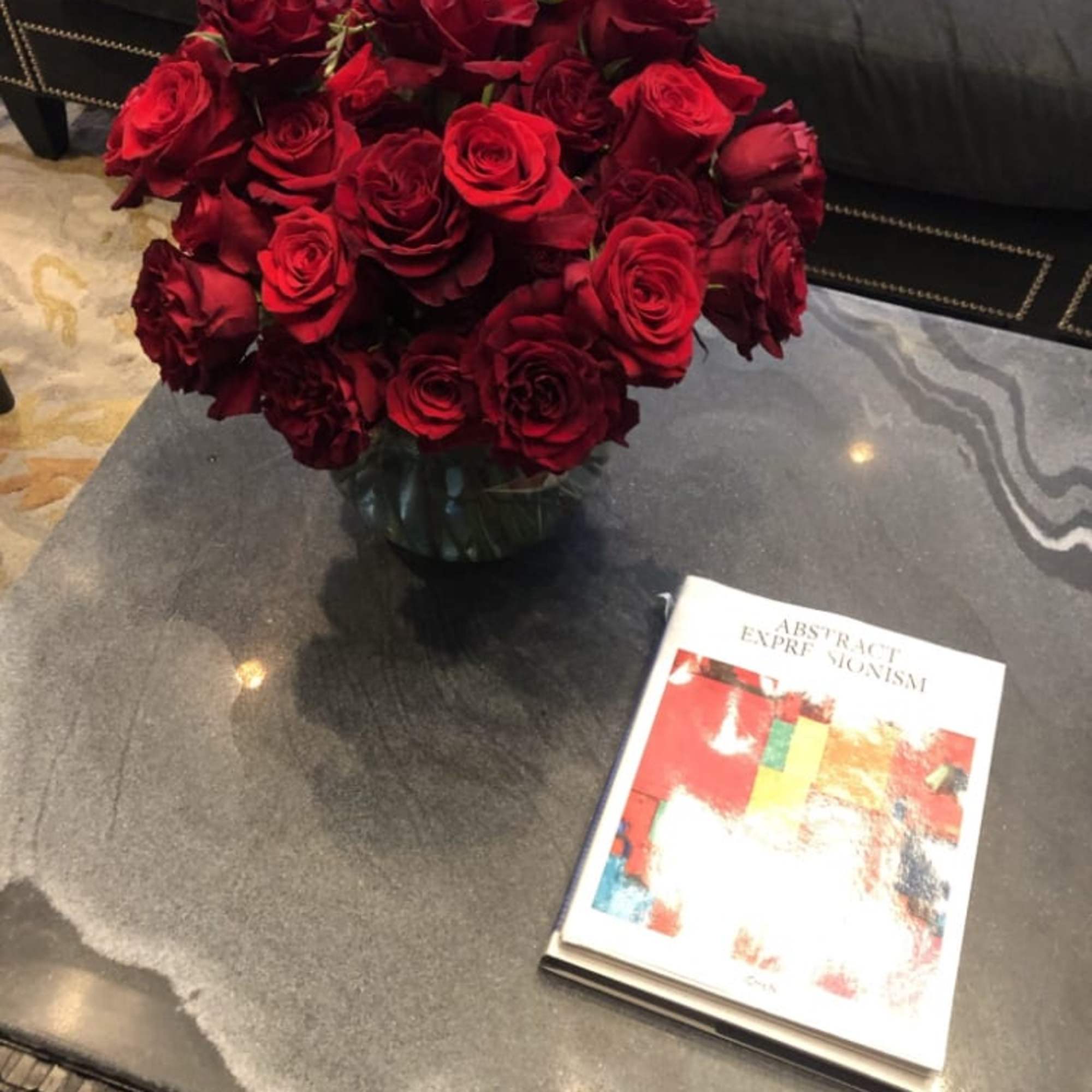 Bouquet of red roses in a glass vase on a table