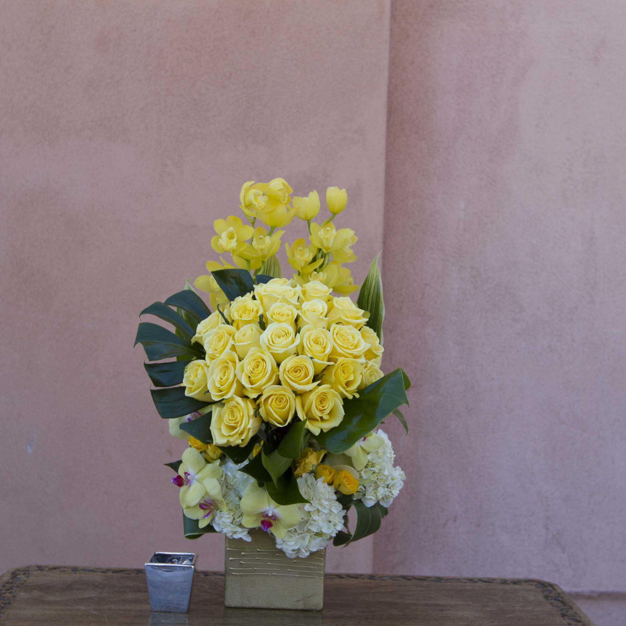 Yellow roses and orchids arranged in a square vase, photo 2 of 2
