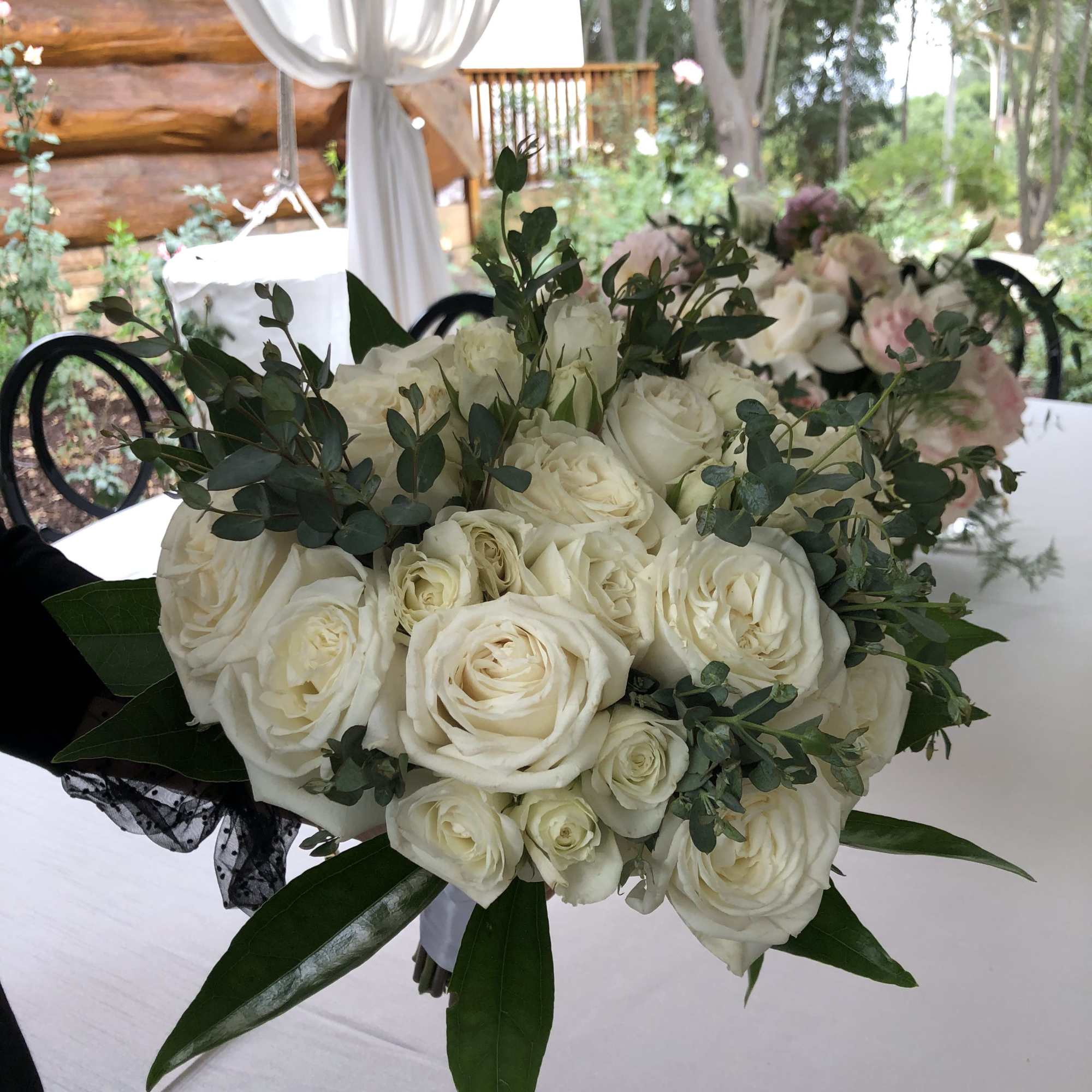 White rose bouquet with greenery on a table